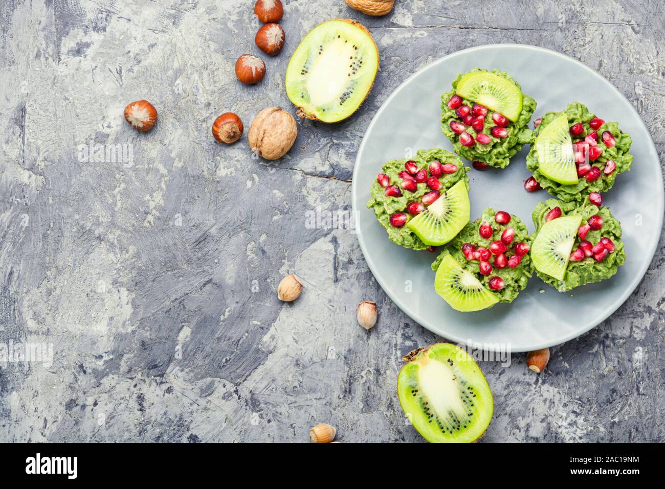 Ernährung avocado Cupcakes oder Muffin garniert mit Kiwi und Granatapfel. Fee Kuchen. Platz für Text Stockfoto