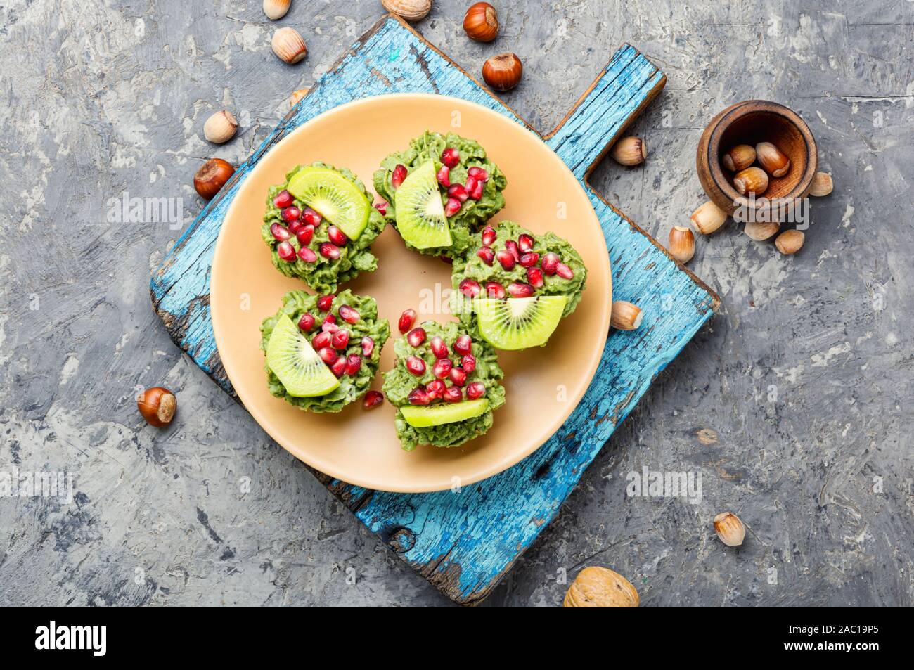 Ernährung avocado Cupcakes garniert mit Kiwi und Granatapfel. Fairy cake Stockfoto