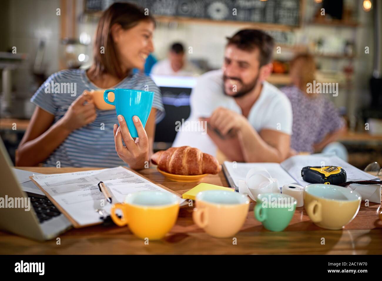 Lächelndes Paar öffnen eine Cafeteria und Cups Stockfoto