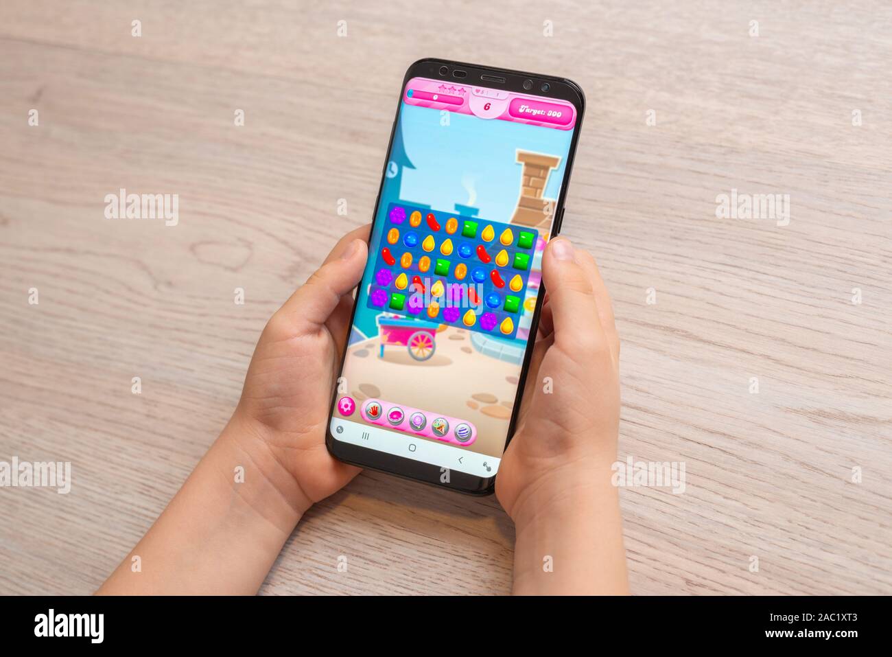 Sarajevo, Bosnien und Herzegowina - 30. November 2019: Candy Crush Saga puzzle video Spiel auf moderne smart phone in Kid Hände close-up Stockfoto