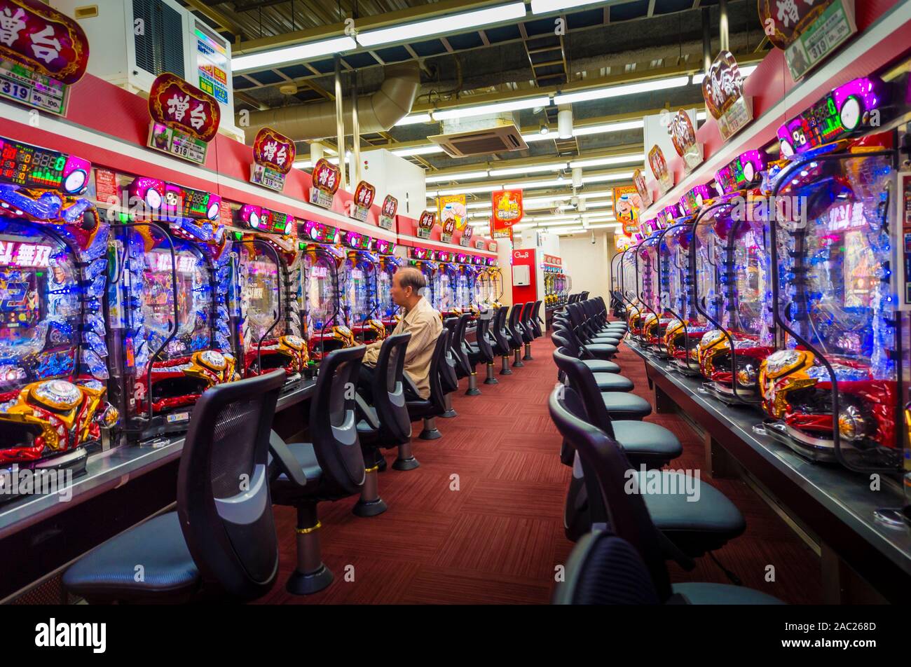 Tokyo, Japan - 12 Okt 2018: Eine ältere Japaner ist das Glücksspiel an einem Pachinko slot Maschine innerhalb eines Pachinko Salon in Tokio, Japan. Stockfoto