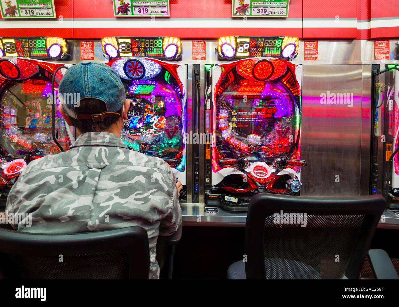 Tokyo, Japan - 12 Okt 2018: ein Japaner ist das Glücksspiel an einem Pachinko slot Maschine innerhalb eines Pachinko Salon in Tokio, Japan. Stockfoto