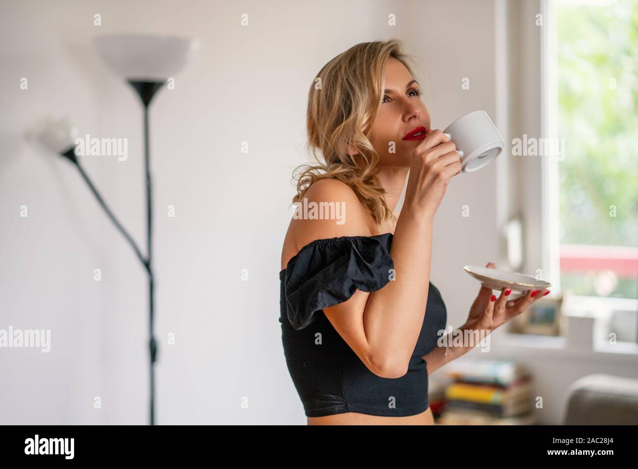 Mädchen mit Tasse Kaffee oder Tee. Frau Getränke Tasse Kaffee oder Tee auf einem sonnigen Morgen Stockfoto