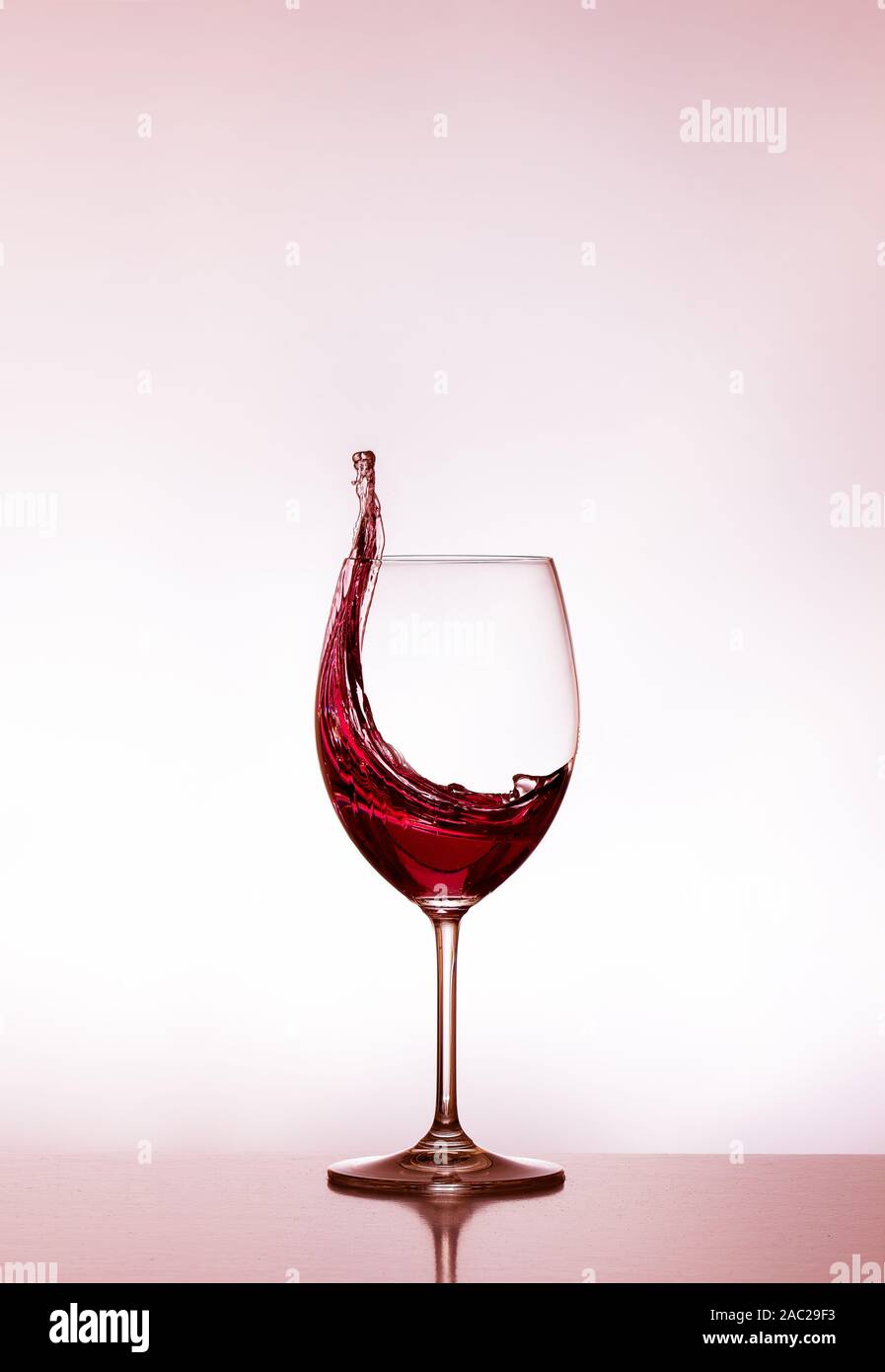 Glas Rotwein - das Glas halb voll - das Glas halb leer - Spritzer Wein - Wein verschüttet ist Stockfotografie