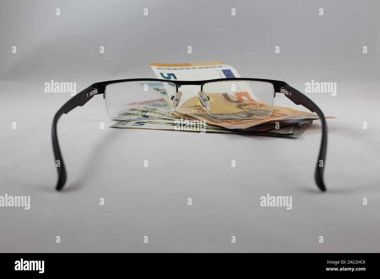 Blurry Gläser Festlegung auf Geld Konzept manchmal besser sehen ohne Brille, ausgewählte konzentrieren sich auf das Geld Stockfoto