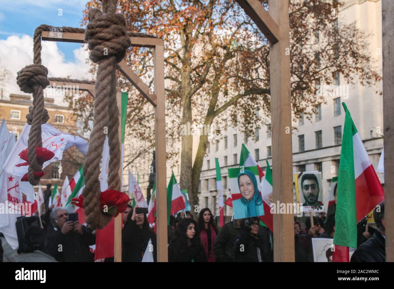 London, Großbritannien. 30 Nov, 2019. Die Anglo-iranischen Gemeinschaften in Großbritannien und Unterstützer des Nationalen Widerstandsrats Iran (NWRI) eine Kundgebung abhielten gegenüber Downing Street zur Unterstützung der laufenden Proteste im Iran, die in einen Aufstand gegen das klerikale Regime gedreht haben. Über 450. Die Demonstranten wurden getötet und 4000 verletzt, wenn der FTP- und Sicherheitskräfte das Feuer auf sie eröffnet. Mehr als 10.000 verhaftet wurde, einer Frau mit einem Foto von einem der Getöteten. Paul Quezada-Neiman/Alamy Live News Credit: Paul Quezada-Neiman/Alamy leben Nachrichten Stockfoto