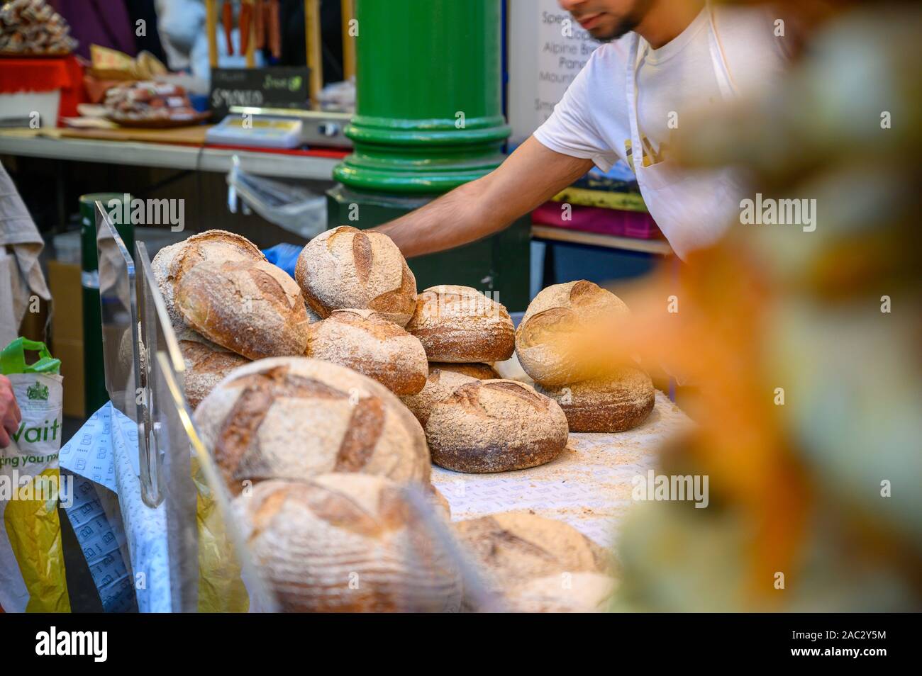 LONDON - September 27, 2019: ein ladenbesitzer Auswahl Brote für ein Kunde an einem Brot in Borough Market, London. Stockfoto
