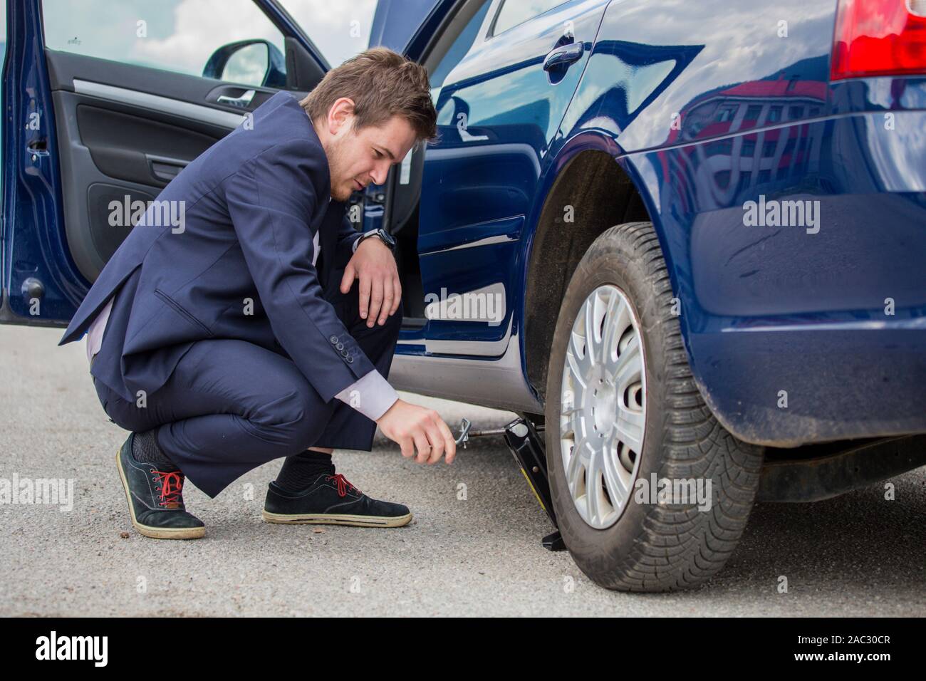 Ändern der Reifen, ein Reserve mit einem in der Hand gehaltenen Kran auf der Straße Stockfoto