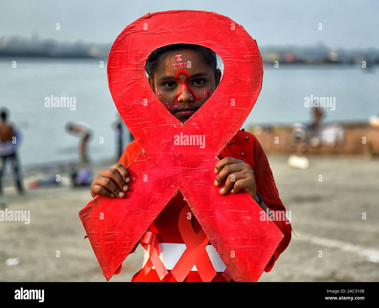 Ein junges Mädchen hält ein Plakat von einem roten Band während des Welt-AIDS-Tag Welt-AIDS-Tag am 1. Dezember jedes Jahr seit 1988. Es ist eine Internationale Tag zur Sensibilisierung der AIDS-Pandemie durch die Ausbreitung der HIV-Infektion verursacht und Trauer, die an der Krankheit gestorben sind. Stockfoto