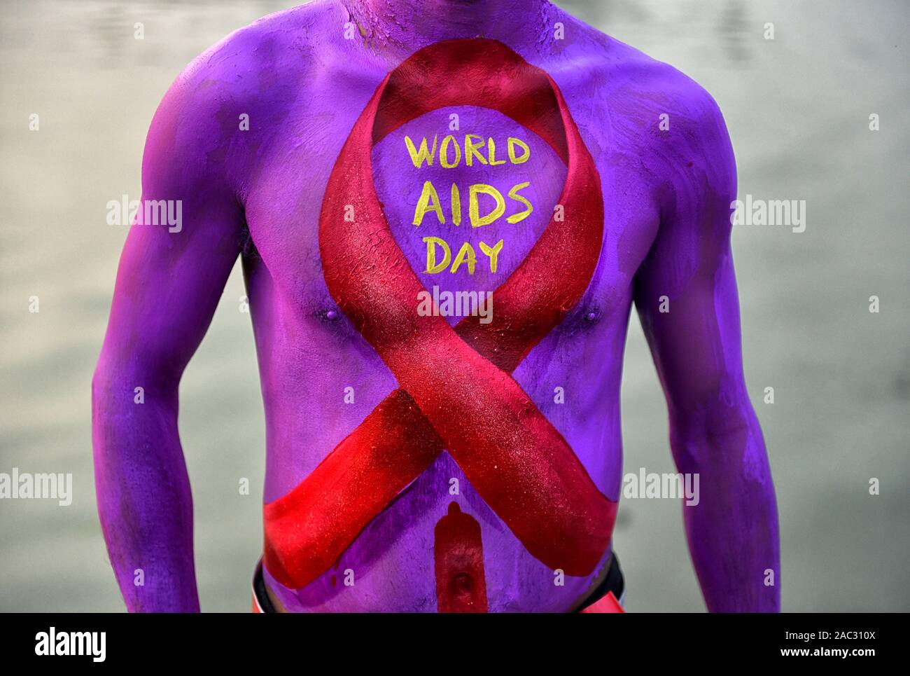 Ein Mann mit einem roten Band Malerei auf seinem Körper während des Welt-AIDS-Tag Welt-AIDS-Tag am 1. Dezember jedes Jahr seit 1988. Es ist eine Internationale Tag zur Sensibilisierung der AIDS-Pandemie durch die Ausbreitung der HIV-Infektion verursacht und Trauer, die an der Krankheit gestorben sind. Stockfoto