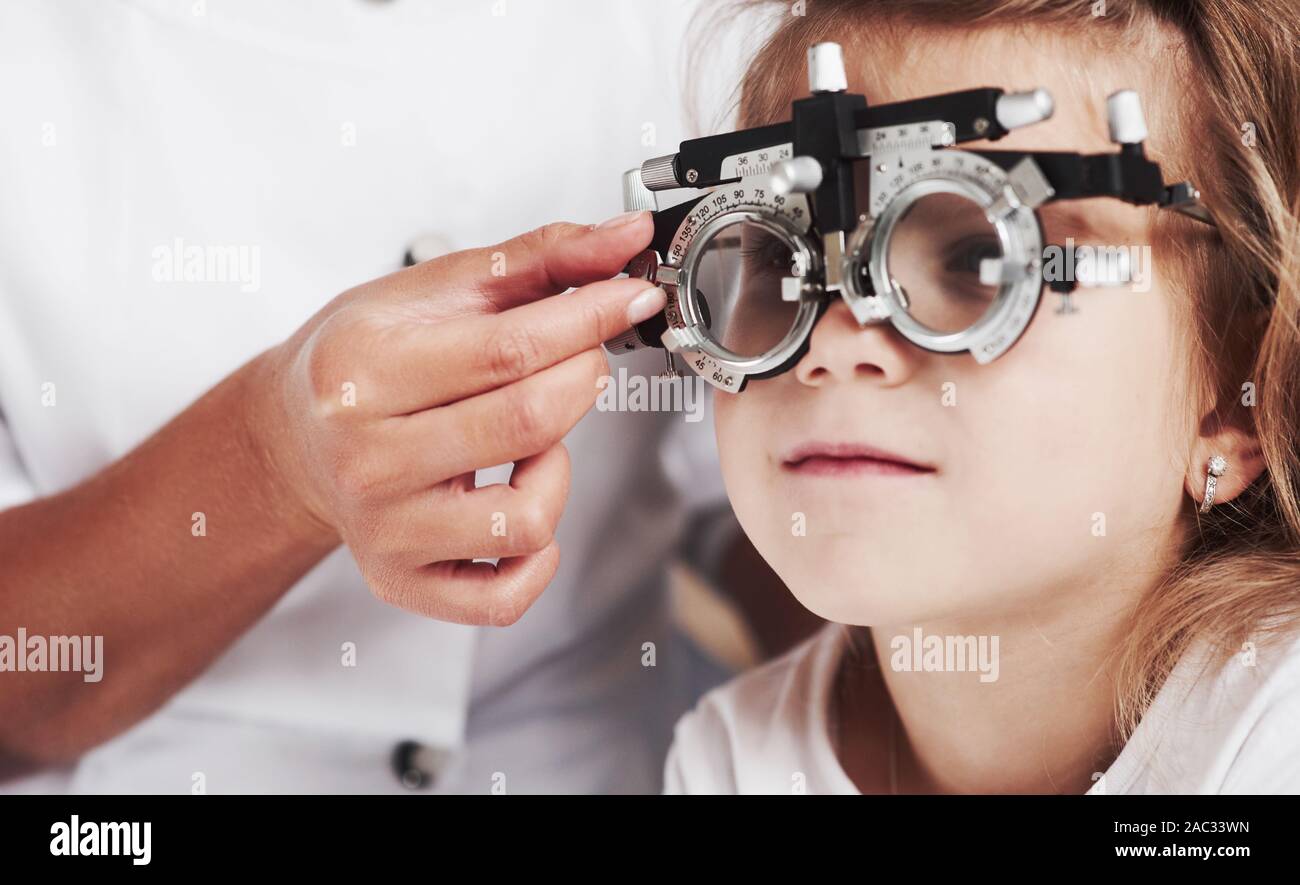 Nahaufnahme Foto. Arzt prüfen kleine Mädchen Anblick und das Tuning der phoroptor Stockfoto