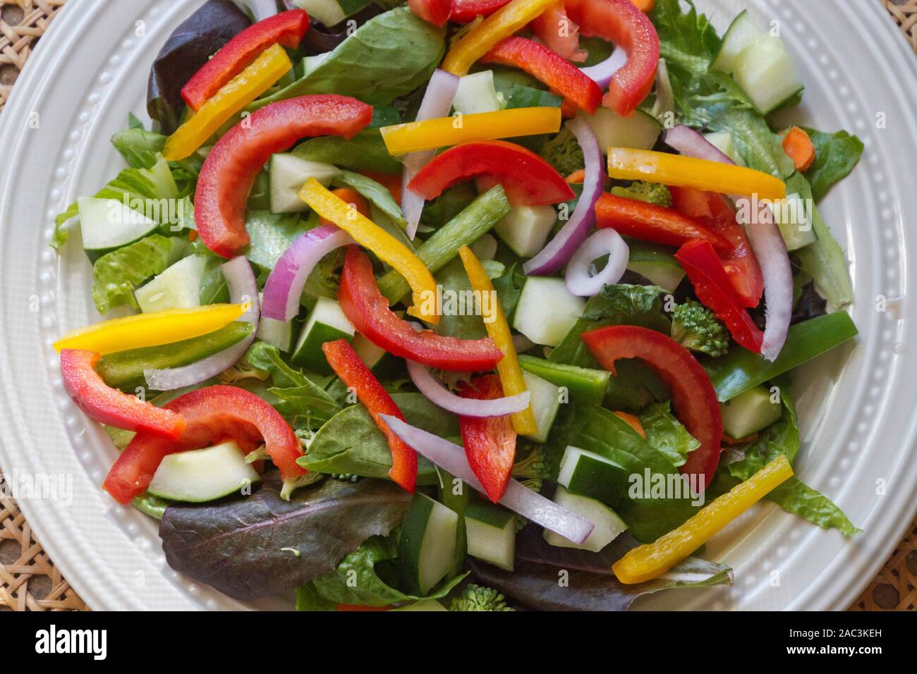 Extreme Nahaufnahme eines gesunden rohen Salat auf einen Teller voll mit bunten Ernährung und Gemüse, einschließlich Spring Mix Grüns, Spinat, Gurken, t Stockfoto