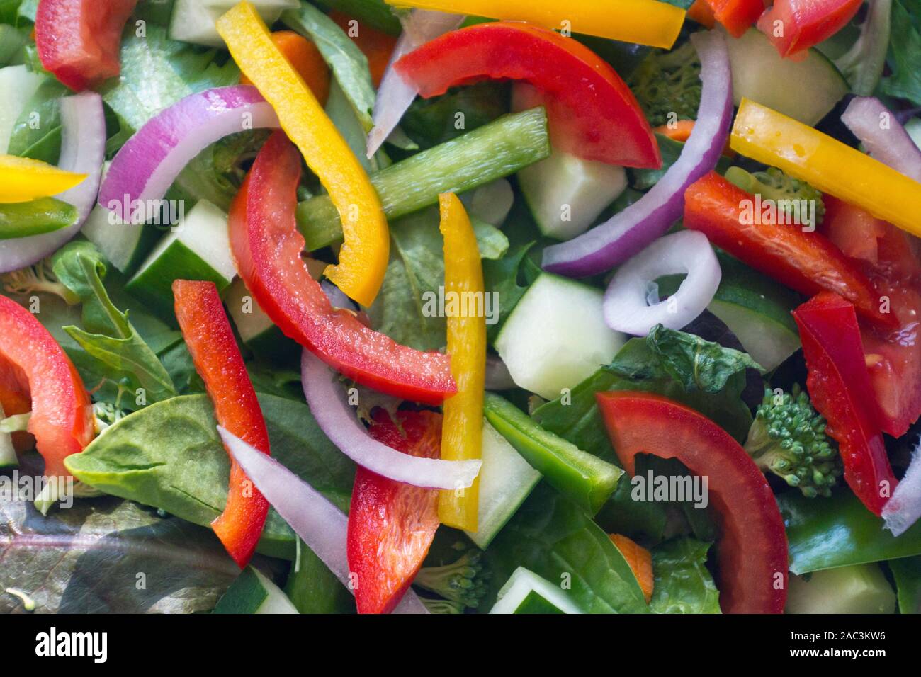 Extreme Nahaufnahme eines gesunden rohen Salat platzen mit bunten Ernährung und Gemüse, einschließlich Spring Mix Grüns, Spinat, Gurken, Tomaten, re Stockfoto