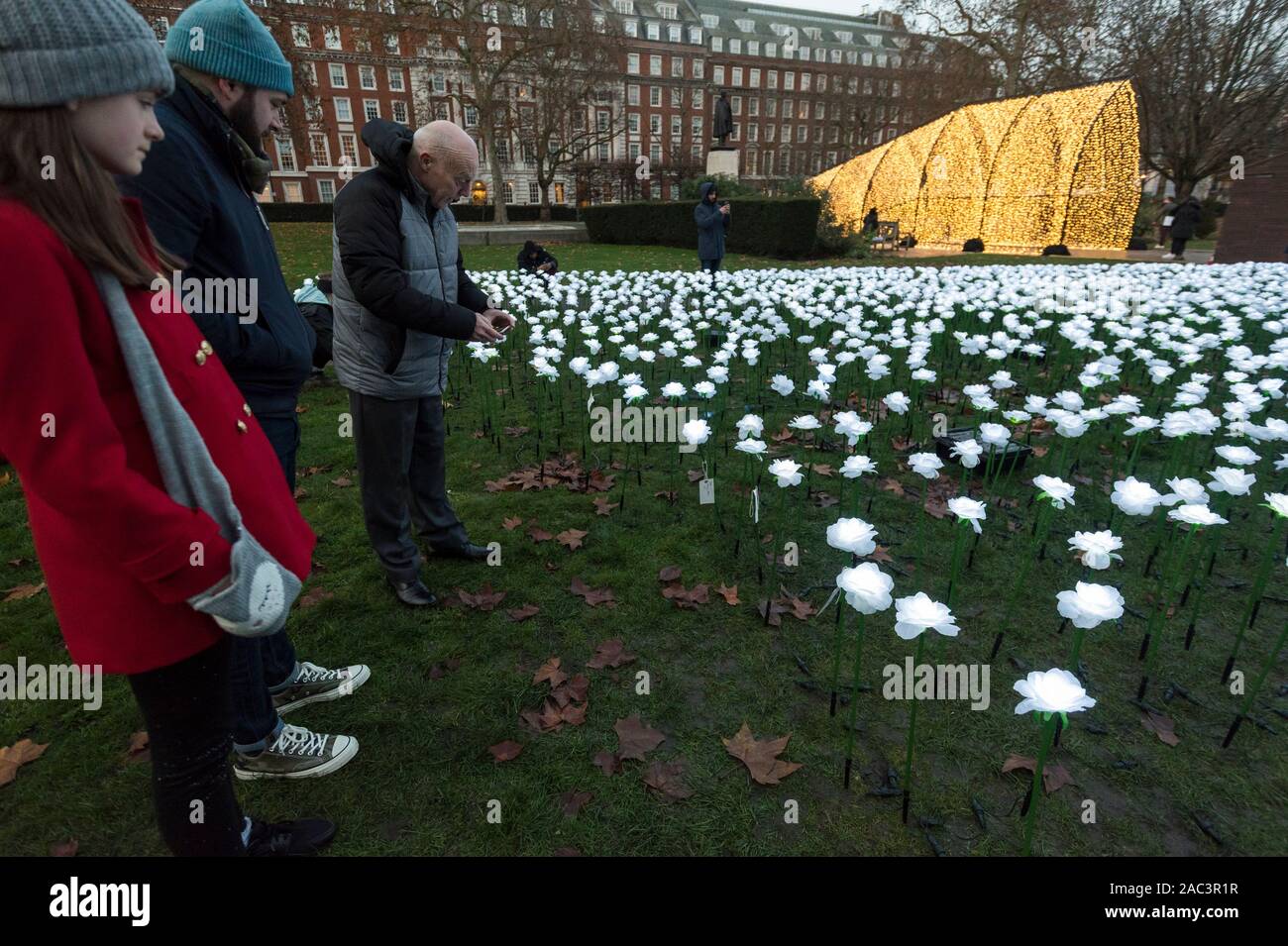 London, Großbritannien. 30. November 2019. Besucher sehen die 'Je nach Garten', die für die Öffentlichkeit im Grosvenor Square eröffnet hat. Von Anya Hindmarch und Camilla Morton in Erinnerung an ihren Freund entworfen und top Production Designer Michael Howells, die Je nach Garten besteht aus einem Raum mit über 27.000 beleuchtete weiße Rosen gefüllt. Besucher können die Pflanze eine Rose in Erinnerung an geliebte Menschen verloren haben, die Kosten für jede Rose helfen, Kapital für die Royal Marsden Krebs Nächstenliebe anzuheben. Der Garten ist bis 22. Dezember. Credit: Stephen Chung/Alamy leben Nachrichten Stockfoto