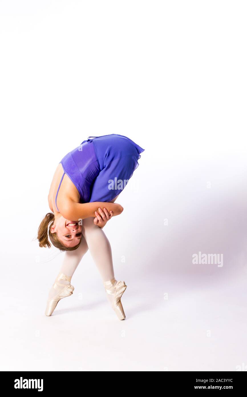 Ballerina en Pointe in einem lila Kleid. Studio gedreht. High-key. Stockfoto