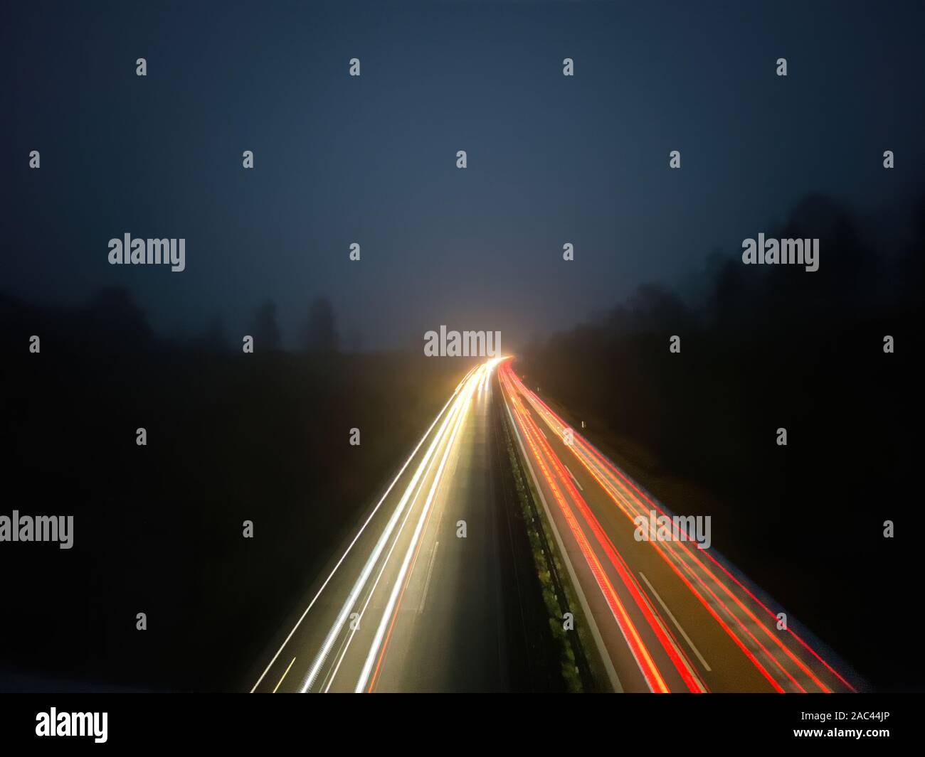 Helle Streifen von fahrenden Autos auf einer deutschen Autobahn bei Nacht Stockfoto