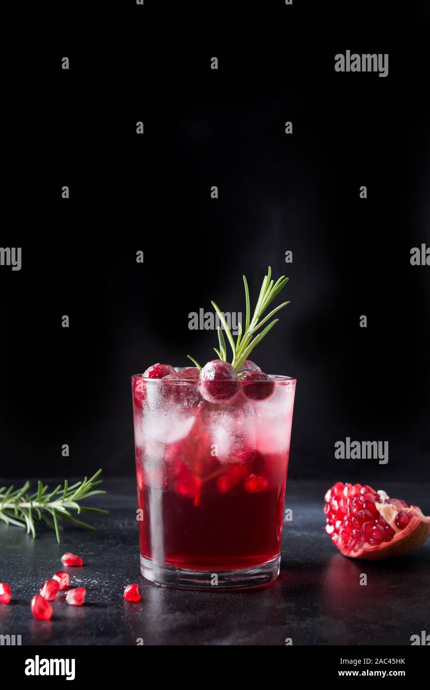 Granatapfel Weihnachten Cocktail mit Rosmarin, Champagner, club Soda auf grauem Beton Tabelle. Close Up. Stockfoto