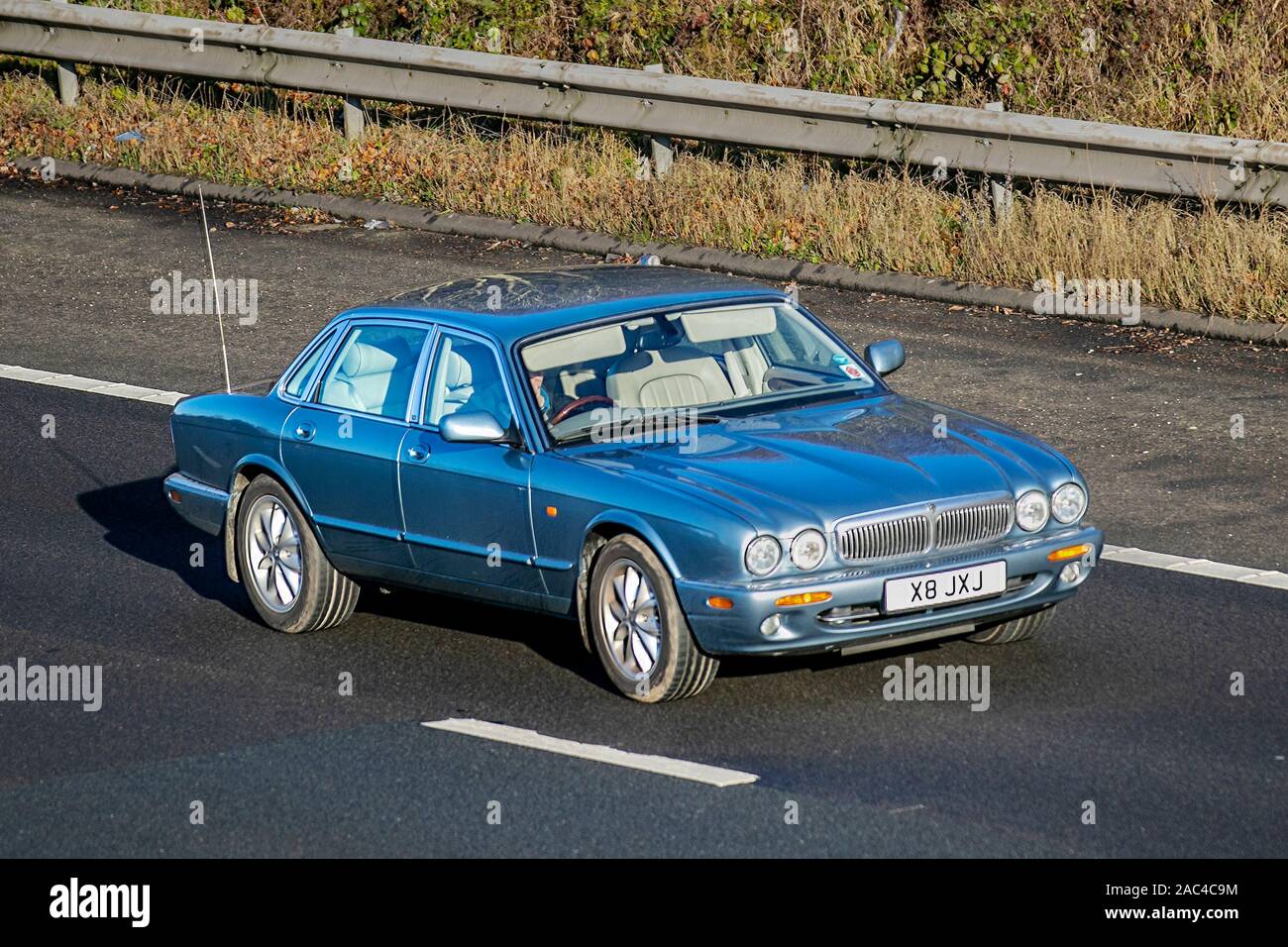 2002 blauer Jaguar XJ Executive Auto; Verkehr, Transport, britische Fahrzeuge, Limousinen, Fahrzeuge, Fahrzeuge, britische Straßen, Motoren, auf der Autobahn M61 mit 3 Fahrspuren in südlicher Richtung Stockfoto