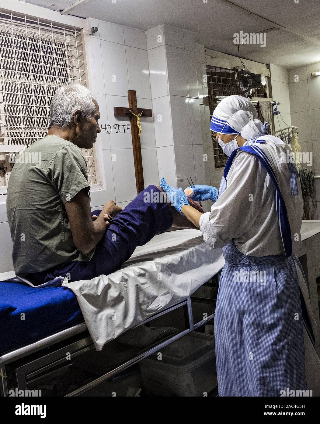 Mutter Teresa Schwester, die einen Patienten zu Hause wegen des Sterbens in Kolkata, Indien, behandelt Stockfoto