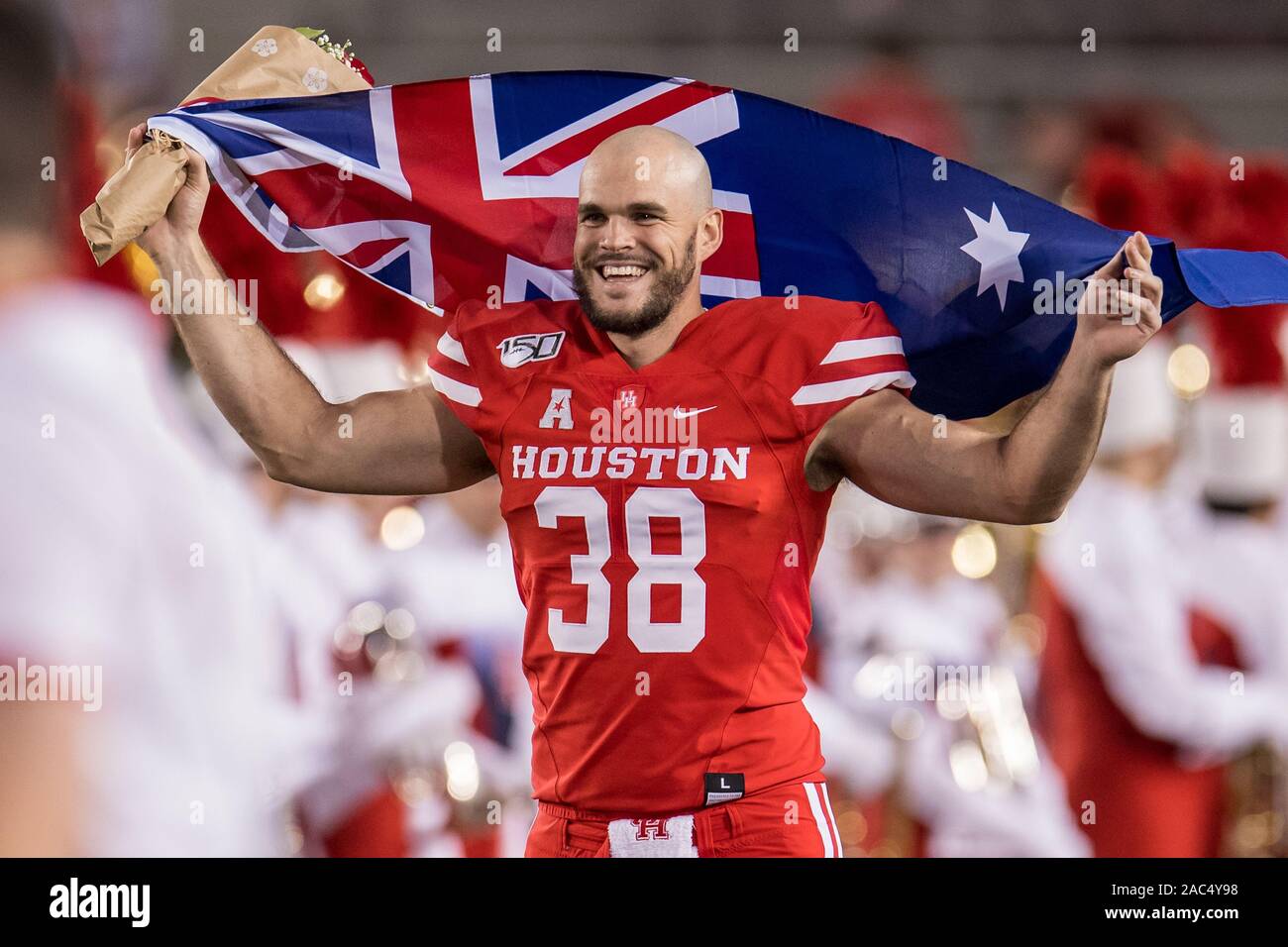 Houston, TX, USA. 30 Nov, 2019. Houston Cougars Börsenspekulant Dane Roy (38) in das Feld vor einem NCAA Football Spiel zwischen den Marinemidshipmen und das Houston Cougars bei tdecu Stadion in Houston, TX Durchführung einer australischen Flagge. Marine gewann das Spiel 56 bis 41. Trask Smith/CSM/Alamy leben Nachrichten Stockfoto