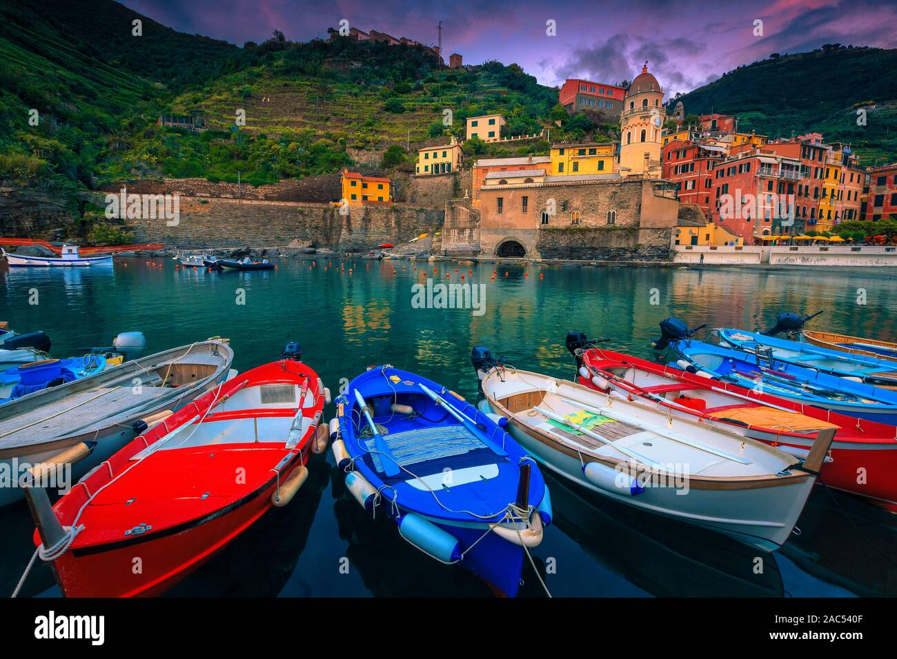 Wunderschönes Resort bei Sonnenuntergang mit bunten mediterranen Gebäude und hölzerne Fischerboote im Hafen. Vernazza, Cinque Terre, Italien, Europa Stockfoto