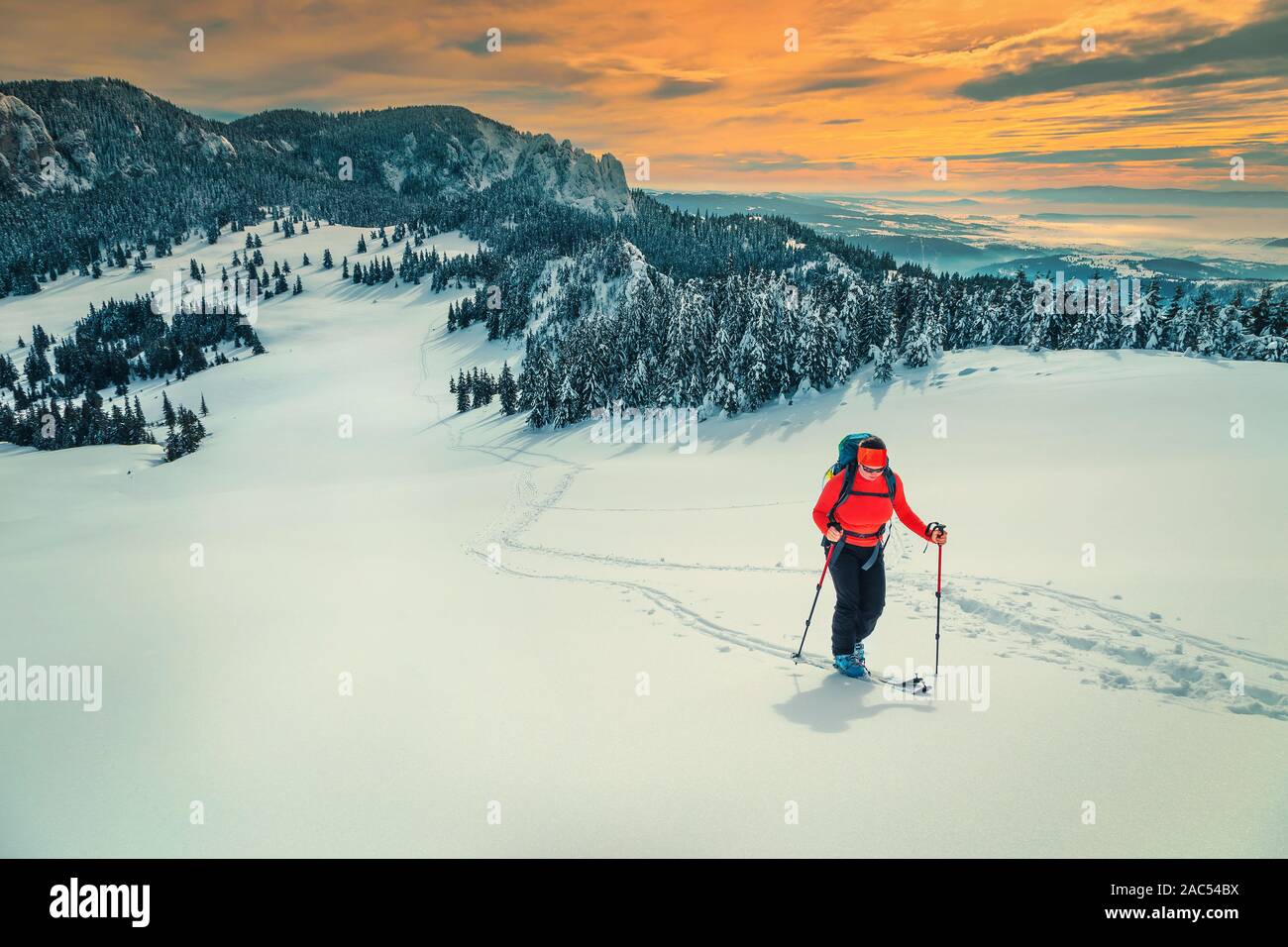 Gerne backpacker Frau auf frischen Pulverschnee, Skitouren auf den verschneiten Hügel. Backcountry skier Frau mit Rucksack und Mountain Equipment am Hang Stockfoto