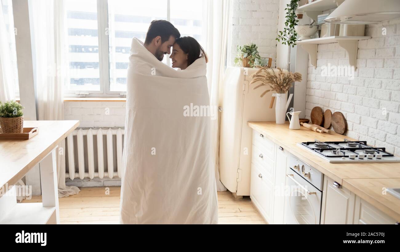 Junge zärtlich Paar stehend in Küche mit Decke gewickelt Stockfoto