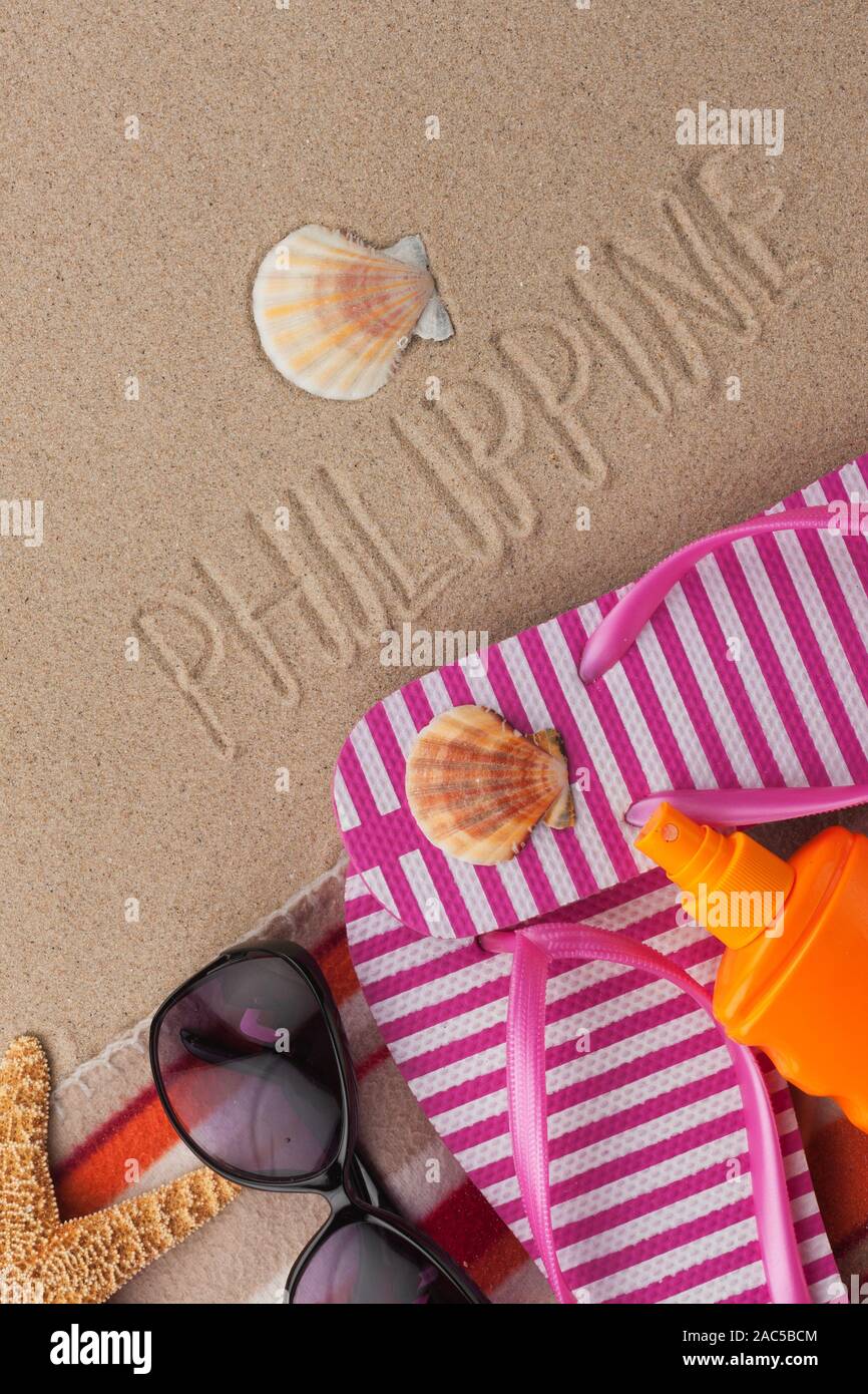 Wort philippinische in Sand mit Strand Zubehör geschrieben. Reisen Hintergrund Stockfoto