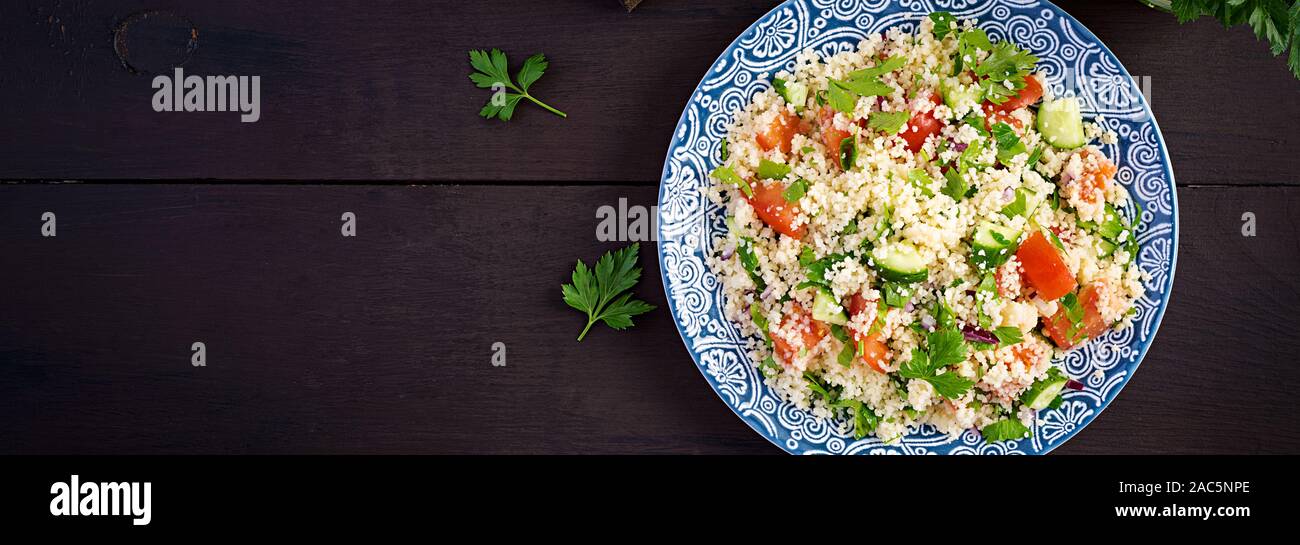 Traditionelle libanesische Salat Tabbouleh. Couscous mit Petersilie, Tomate, Gurke, Zitrone und Olivenöl. Nahöstlichen Küche. Ansicht von oben, Banner Stockfoto