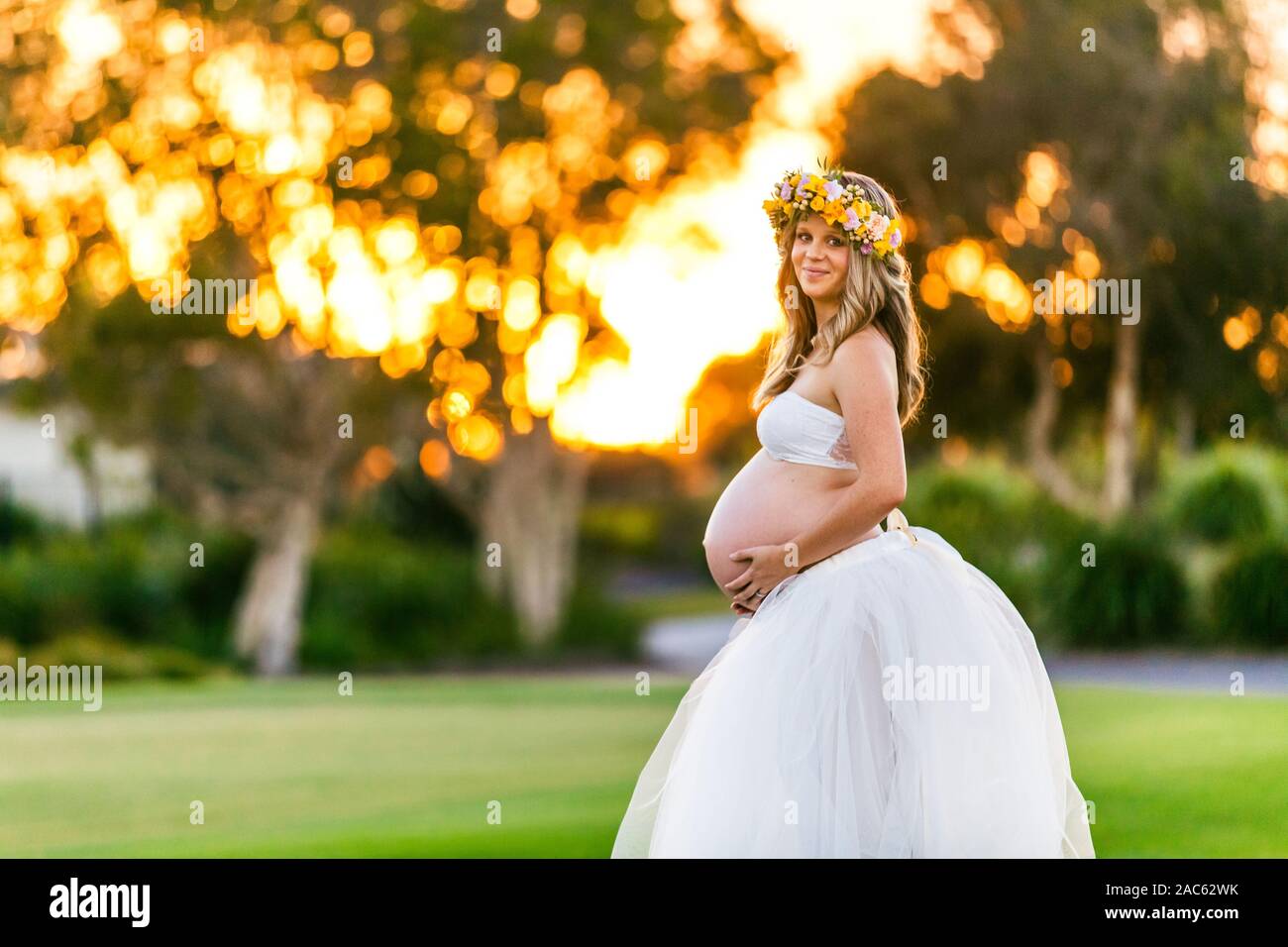 Gerne schwangere Frau mit langem Haar an einem sonnigen Tag, Strand und