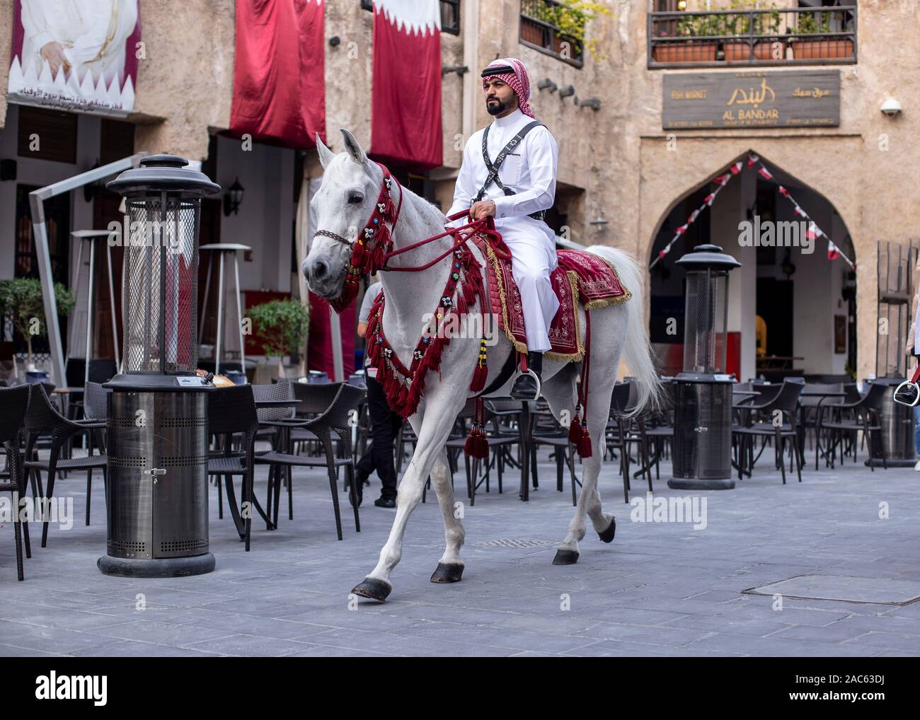 Polizisten in traditionellen 1940 s Qatari einheitliche Reiten white Arabian Horse in Souq Waqif. Beliebte Touristenattraktion in Doha City. Stockfoto