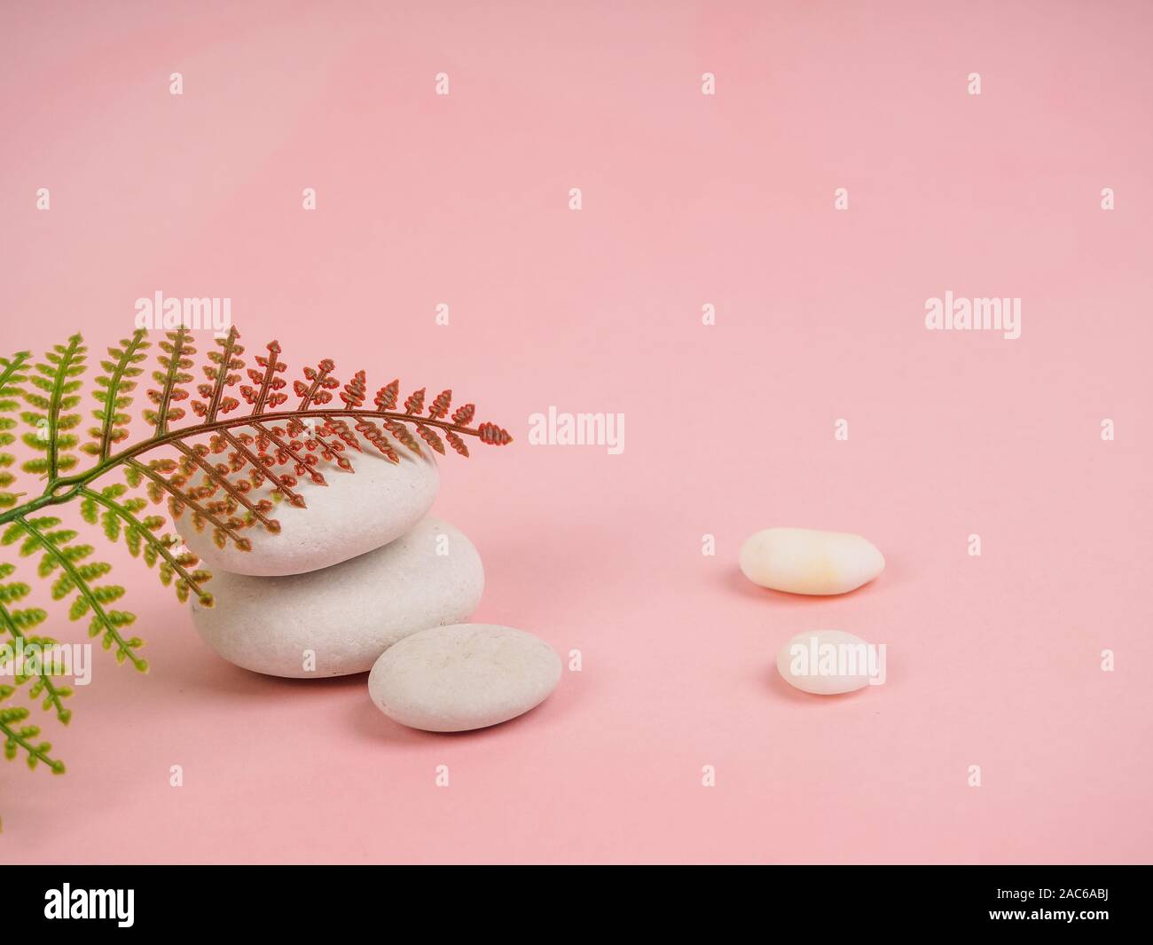 Stapel von Zen-Steinen auf abstraktem rosa Hintergrund. Entspannen Sie Stillleben mit gefalteten Steinen. Zen Kieselsteine, Steine, Spa-ruhige Szenen, um das Leben zu verlangsamen. Mit Stockfoto