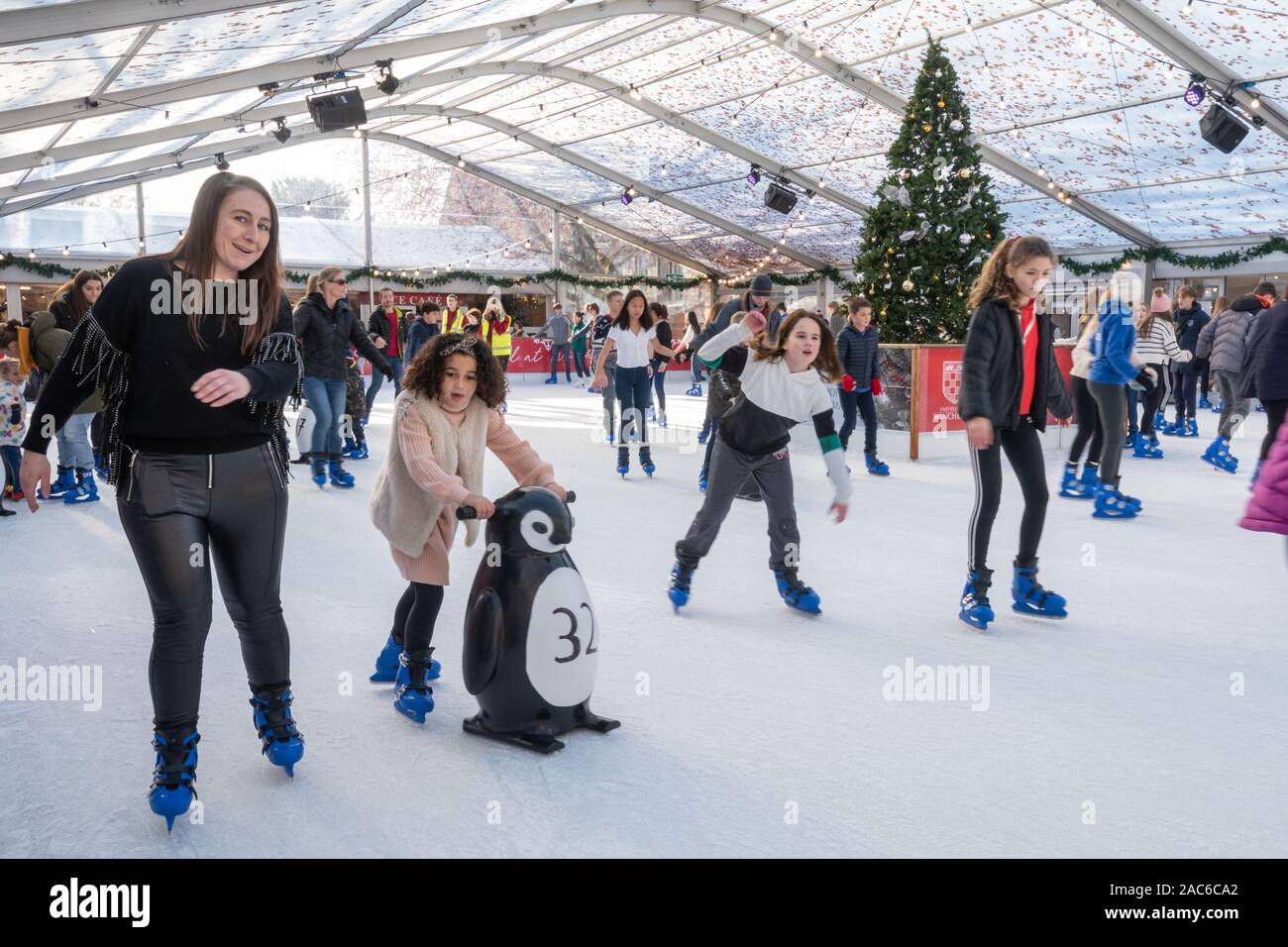 Leute Eislaufen auf der Eisbahn in Winchester Innenstadt während der Weihnachtszeit, Hampshire, Großbritannien Stockfoto