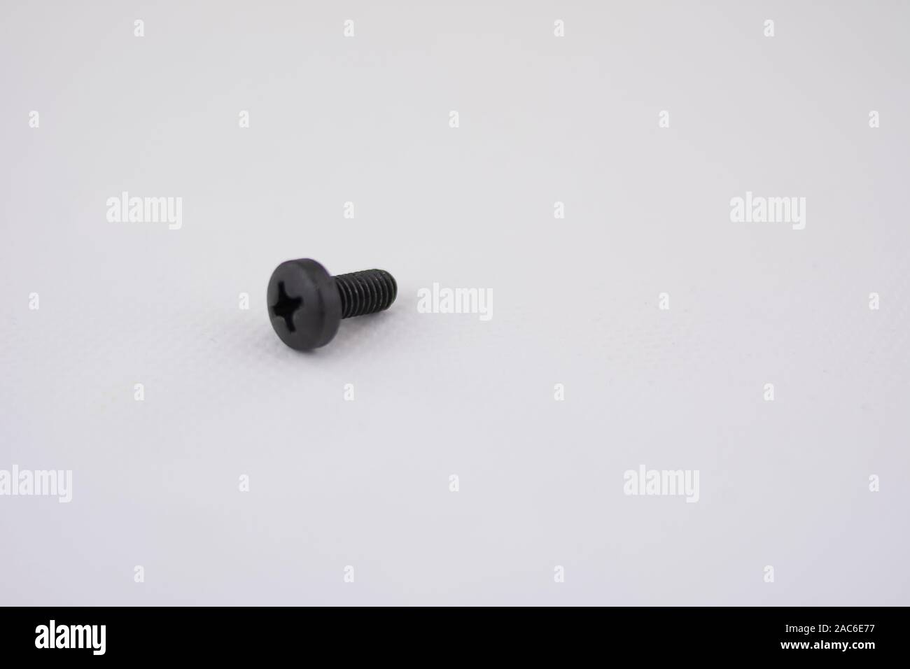 Eine metallische schwarze Schraube isoliert und mit dem Fokus auf die Körper auf weißem Hintergrund Stockfoto