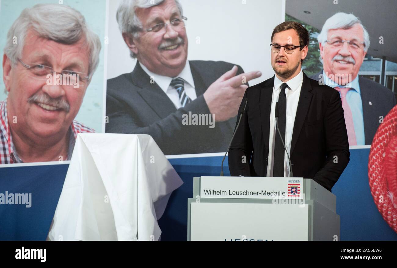 Wiesbaden, Deutschland. 01 Dez, 2019. Jan-Hendrik Lübcke, Sohn von Walter Lübcke, spricht nach der Preisverleihung. Im Hintergrund kann man tolle Portraits von Walter Lübcke. Die Wilhelm Leuschner Medaille 2019 wird posthum an Walter Lübcke (CDU), ehemaliger Präsident des Kasseler Regierung, die im Juni erschossen wurde ausgezeichnet. Credit: Andreas Arnold/dpa - ACHTUNG: Verwenden Sie nur im vollständigen Format/dpa/Alamy leben Nachrichten Stockfoto