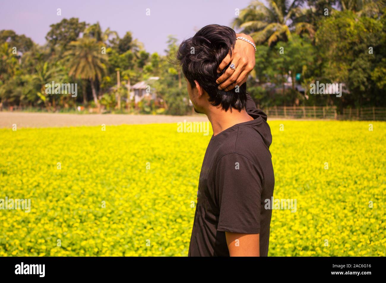 Rückseite eines Jungen, mit schwarzen T-Shirt mit einfachen natürlichen Aufstehen, Hintergrund ist die Natur Stockfoto