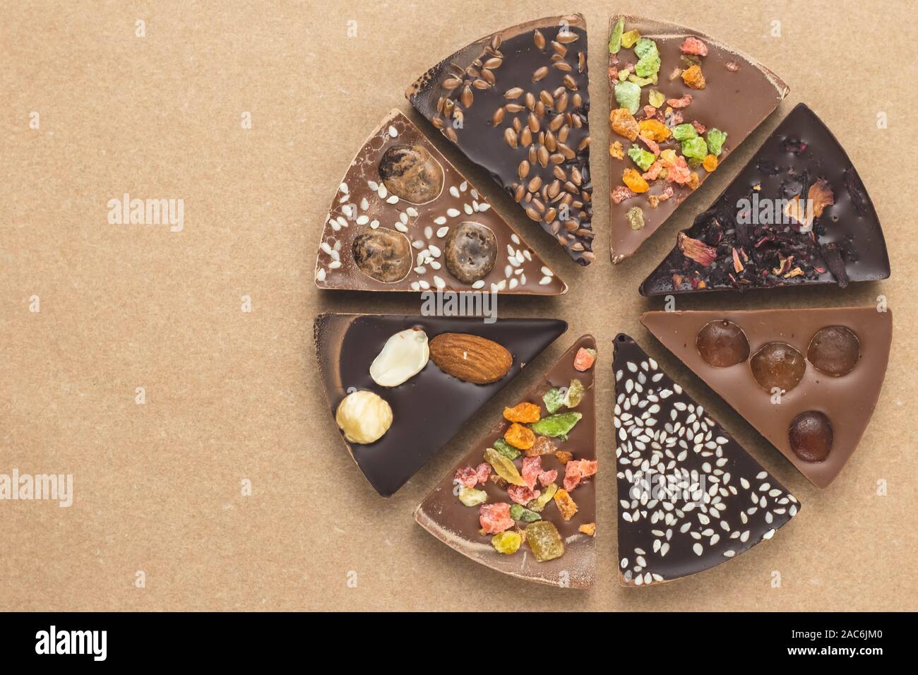 Stücke Schokolade für das Handwerk Papier, Pergament. Art Design. Dunkle Schokolade gewürzt. Essen Hintergrund. Scheiben schwarz und Milchschokolade mit Süßigkeiten, ra Stockfoto