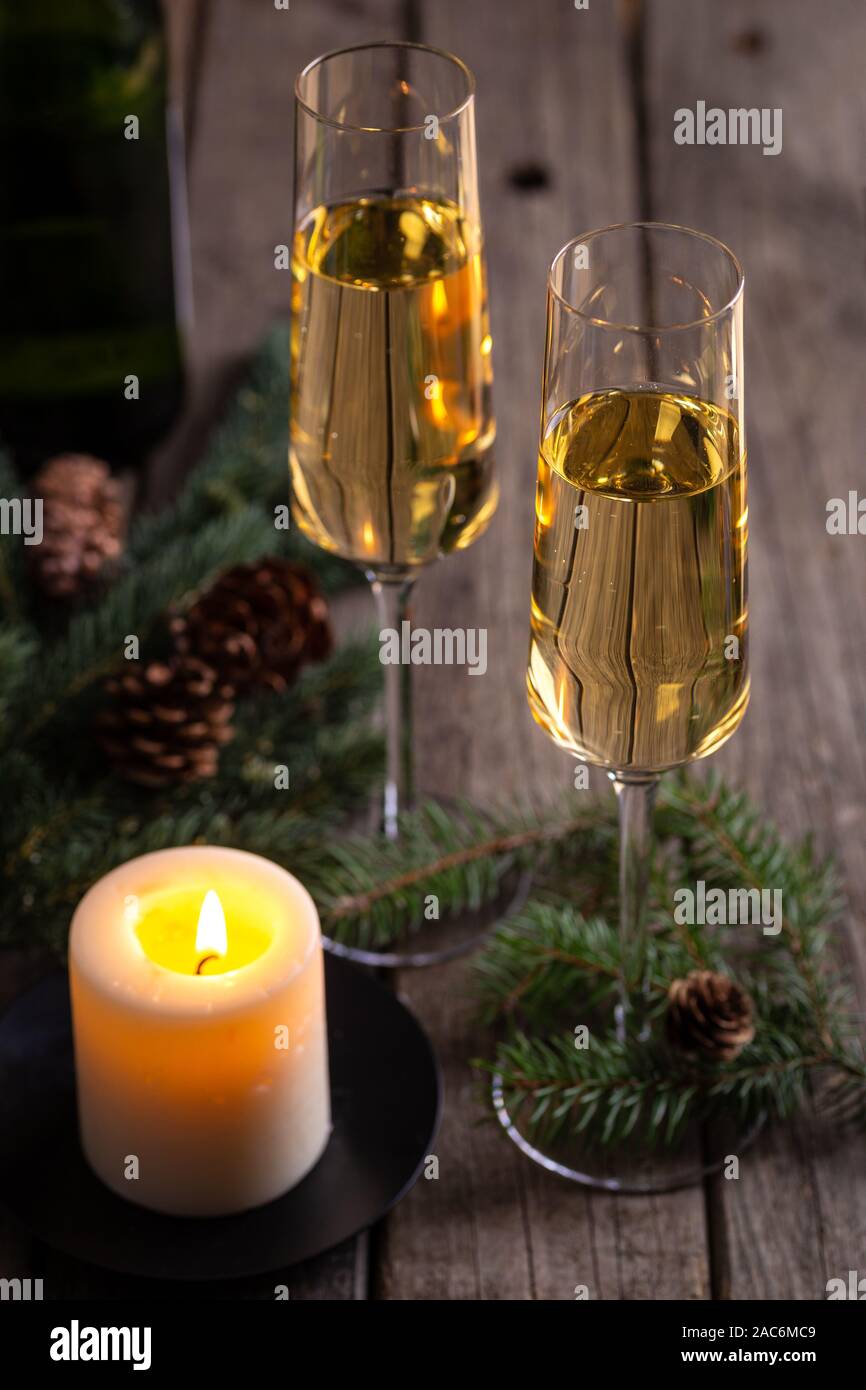 Zwei Gläser Champagner mit brennenden Kerze auf rustikalen Holztisch Stockfoto