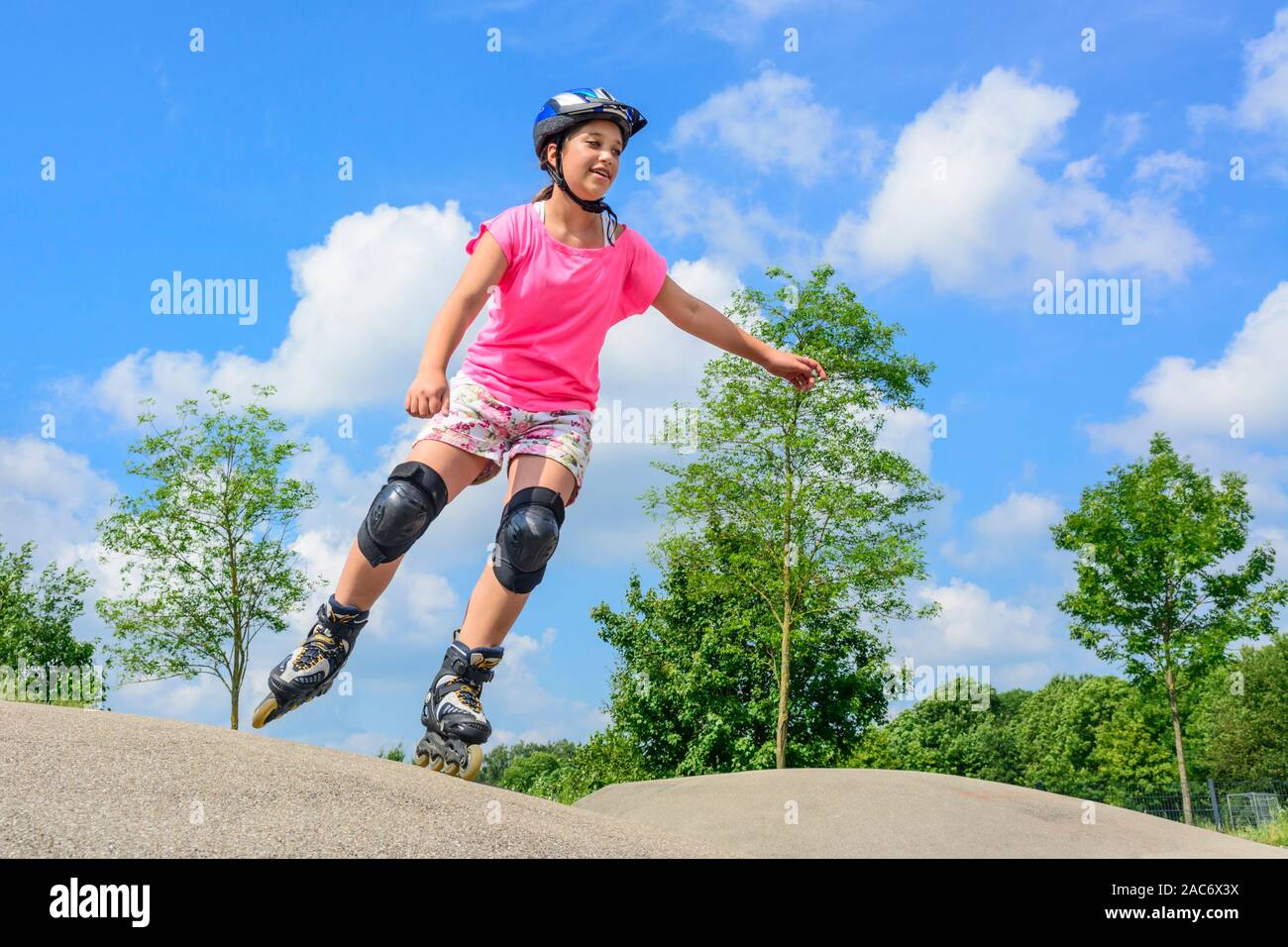 Junger Teenager Spaß auf Inline-skates in städtischen Park an einem sonnigen Mittag im Sommer Stockfoto