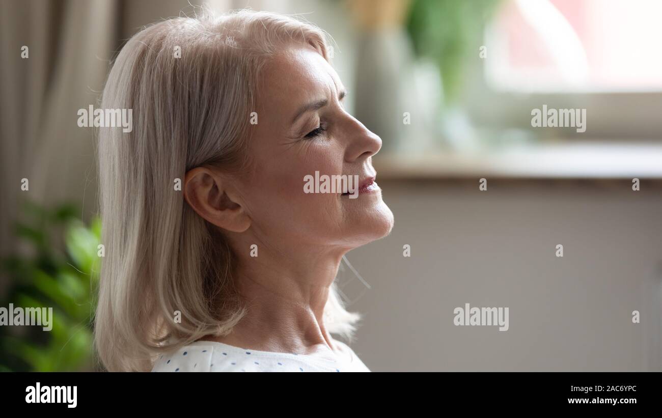 Closeup ruhig 50s Frau geschlossenen Augen genießen Wochenende im Innenbereich Stockfoto