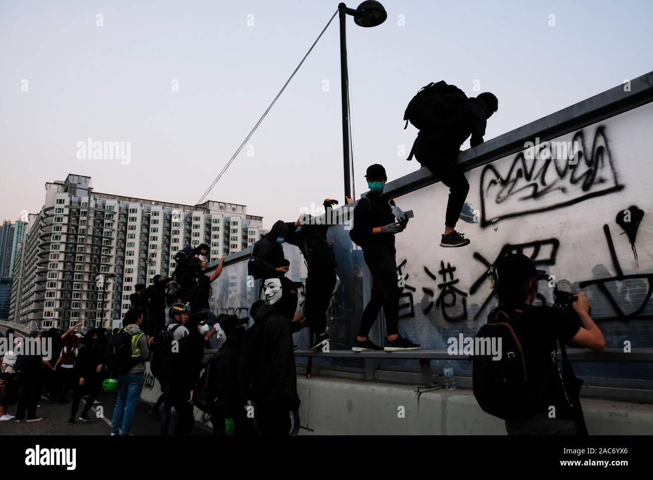 Demonstranten erklimmen Sie den Teiler auf die Überführung nach der Demonstration. Demonstrationen in Hongkong weiterhin als pro-demokratischen Gruppen der Bezirksrat Wahlen gewann vor kurzem. Die Demonstranten weiter für Hongkongs Regierung ihre 5 Anforderungen zu erfüllen. Stockfoto