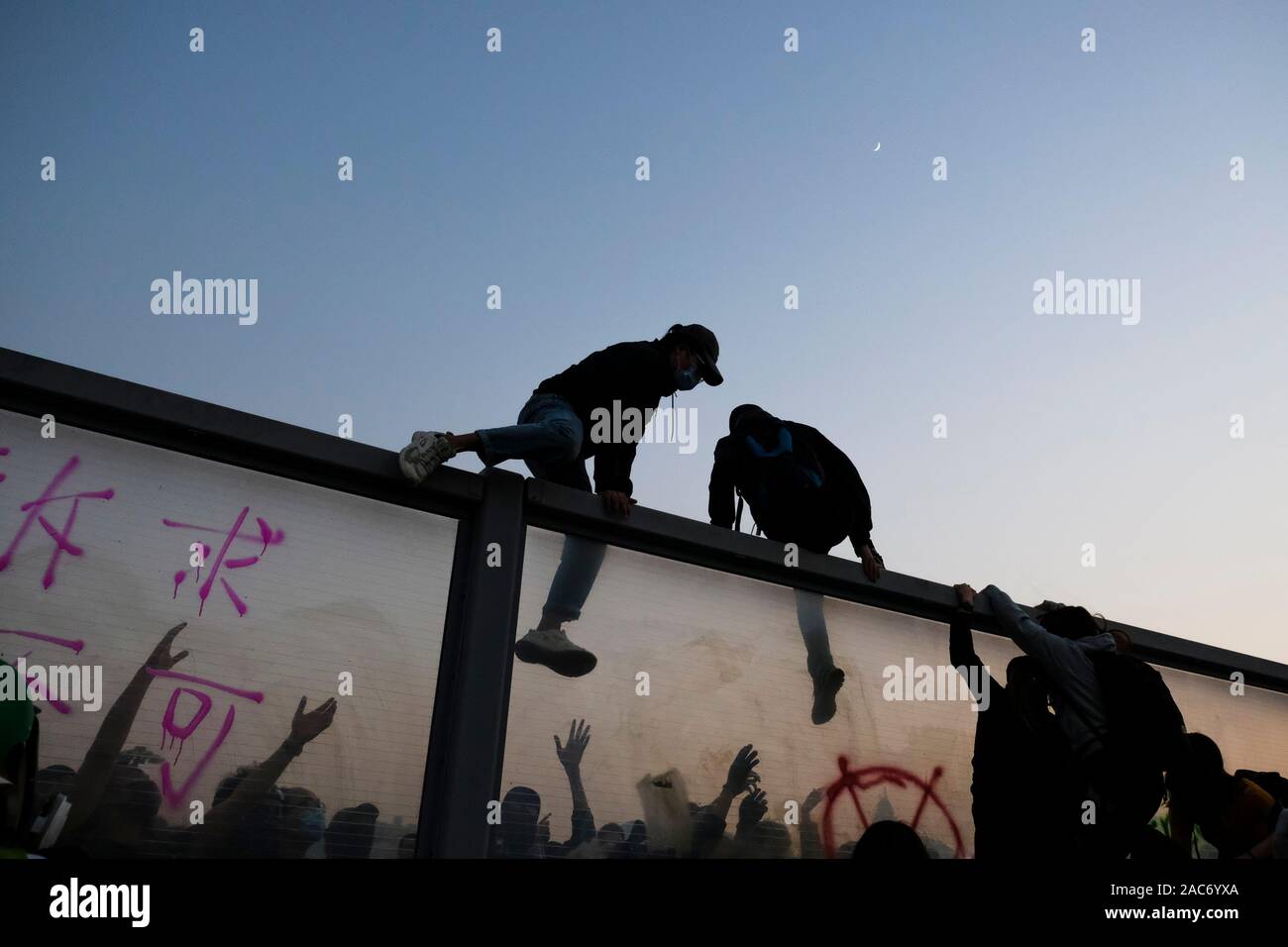 Demonstranten erklimmen Sie den Teiler auf die Überführung nach der Demonstration. Demonstrationen in Hongkong weiterhin als pro-demokratischen Gruppen der Bezirksrat Wahlen gewann vor kurzem. Die Demonstranten weiter für Hongkongs Regierung ihre 5 Anforderungen zu erfüllen. Stockfoto