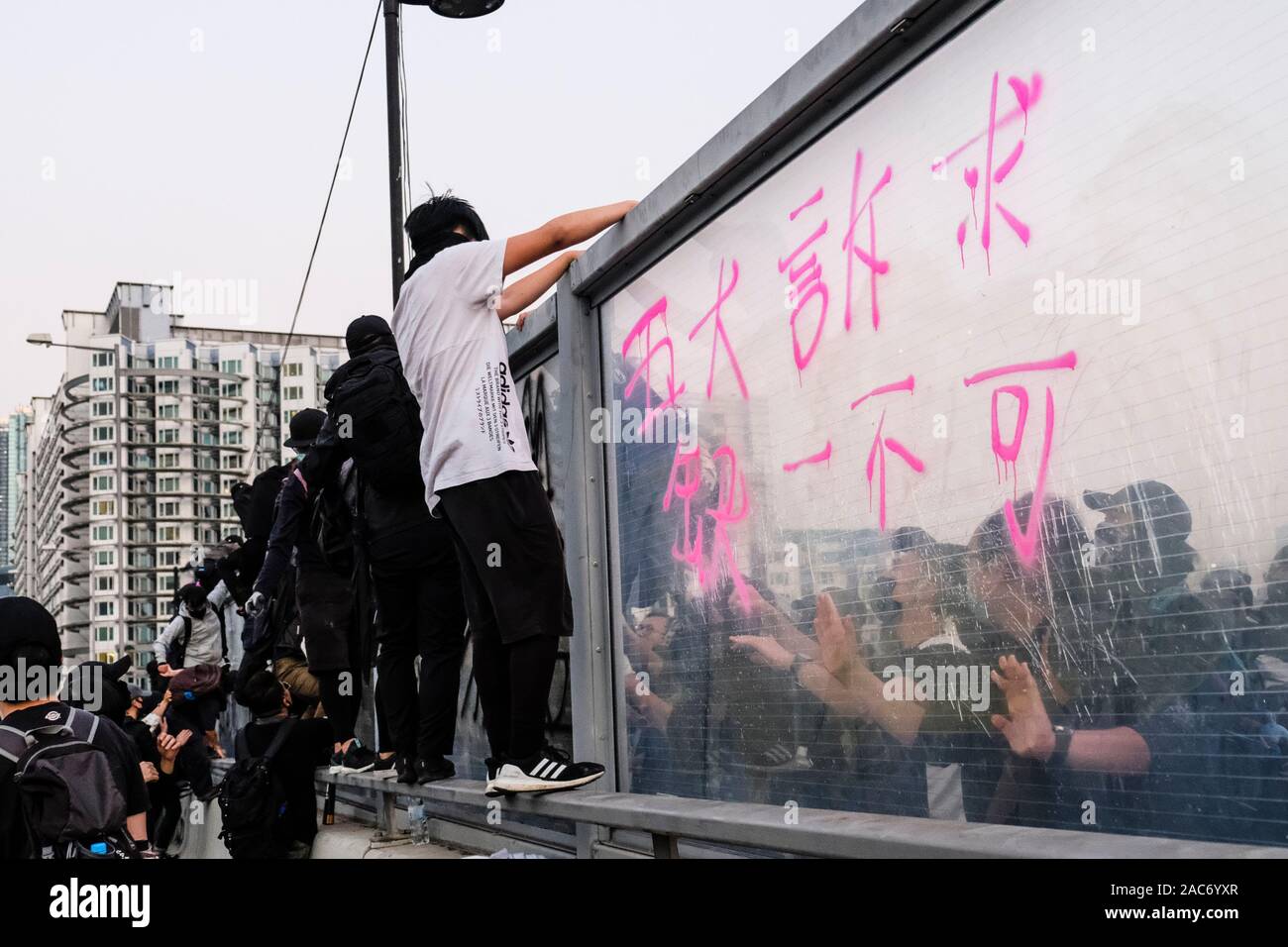 Demonstranten erklimmen Sie den Teiler auf die Überführung nach der Demonstration. Demonstrationen in Hongkong weiterhin als pro-demokratischen Gruppen der Bezirksrat Wahlen gewann vor kurzem. Die Demonstranten weiter für Hongkongs Regierung ihre 5 Anforderungen zu erfüllen. Stockfoto