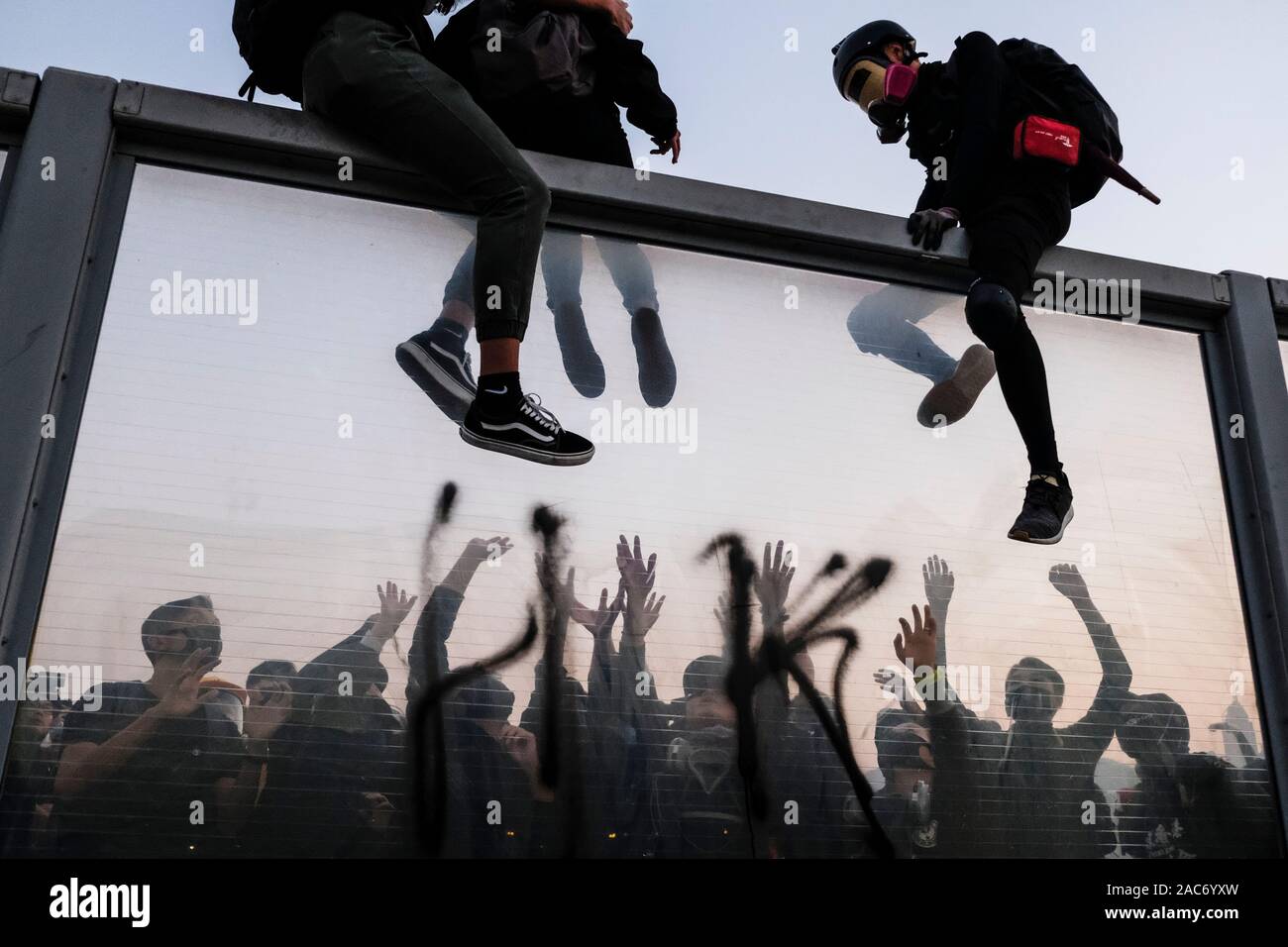 Demonstranten erklimmen Sie den Teiler auf die Überführung nach der Demonstration. Demonstrationen in Hongkong weiterhin als pro-demokratischen Gruppen der Bezirksrat Wahlen gewann vor kurzem. Die Demonstranten weiter für Hongkongs Regierung ihre 5 Anforderungen zu erfüllen. Stockfoto