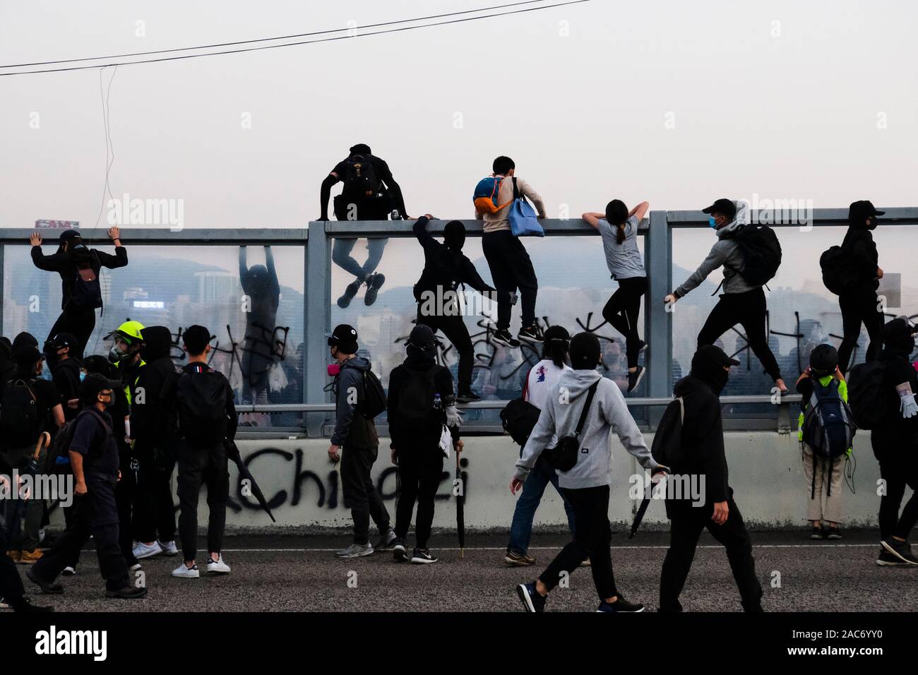 Demonstranten erklimmen Sie den Teiler auf die Überführung nach der Demonstration. Demonstrationen in Hongkong weiterhin als pro-demokratischen Gruppen der Bezirksrat Wahlen gewann vor kurzem. Die Demonstranten weiter für Hongkongs Regierung ihre 5 Anforderungen zu erfüllen. Stockfoto