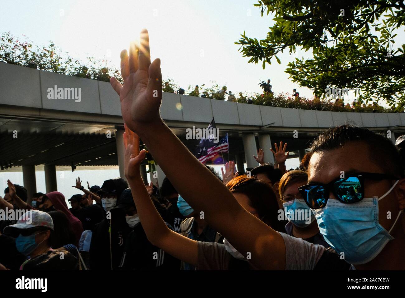 Die Demonstranten mit Staub Masken Gesten während der Demonstration. Demonstrationen in Hongkong weiterhin als pro-demokratischen Gruppen der Bezirksrat Wahlen gewann vor kurzem. Die Demonstranten weiter für Hongkongs Regierung ihre 5 Anforderungen zu erfüllen. Stockfoto