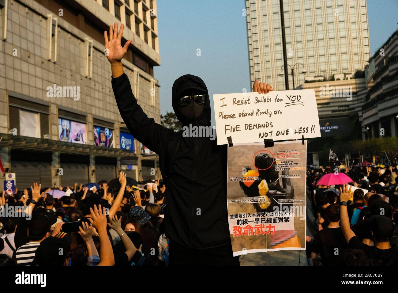 Eine Demonstrantin in Schwarz gekleidet, macht eine Geste, während Sie ein Plakat während der Demonstration. Demonstrationen in Hongkong weiterhin als pro-demokratischen Gruppen der Bezirksrat Wahlen gewann vor kurzem. Die Demonstranten weiter für Hongkongs Regierung ihre 5 Anforderungen zu erfüllen. Stockfoto