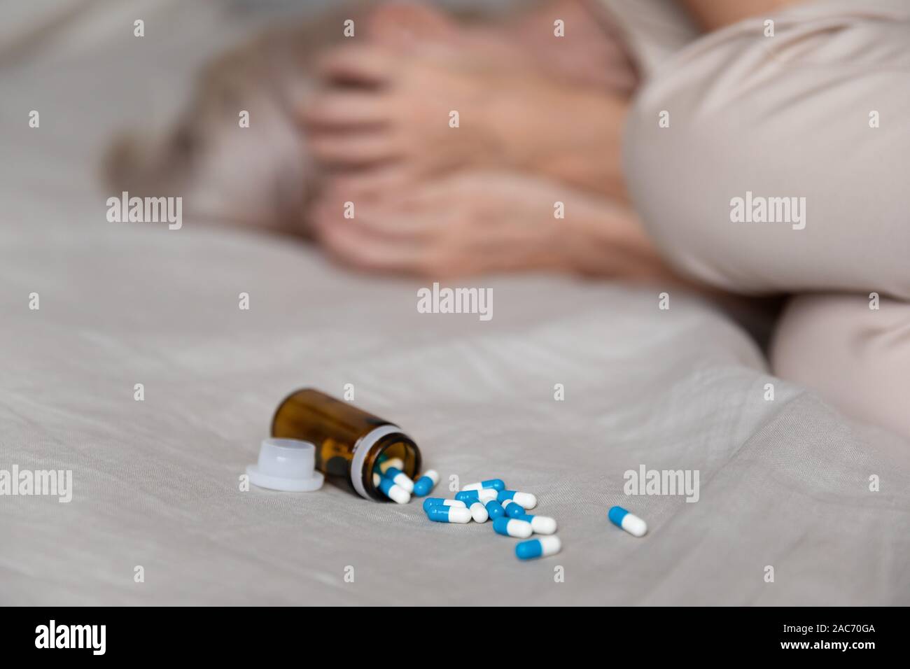 Deprimiert Frau im Bett lag, schrie closeup Fokus auf Pillen Stockfoto