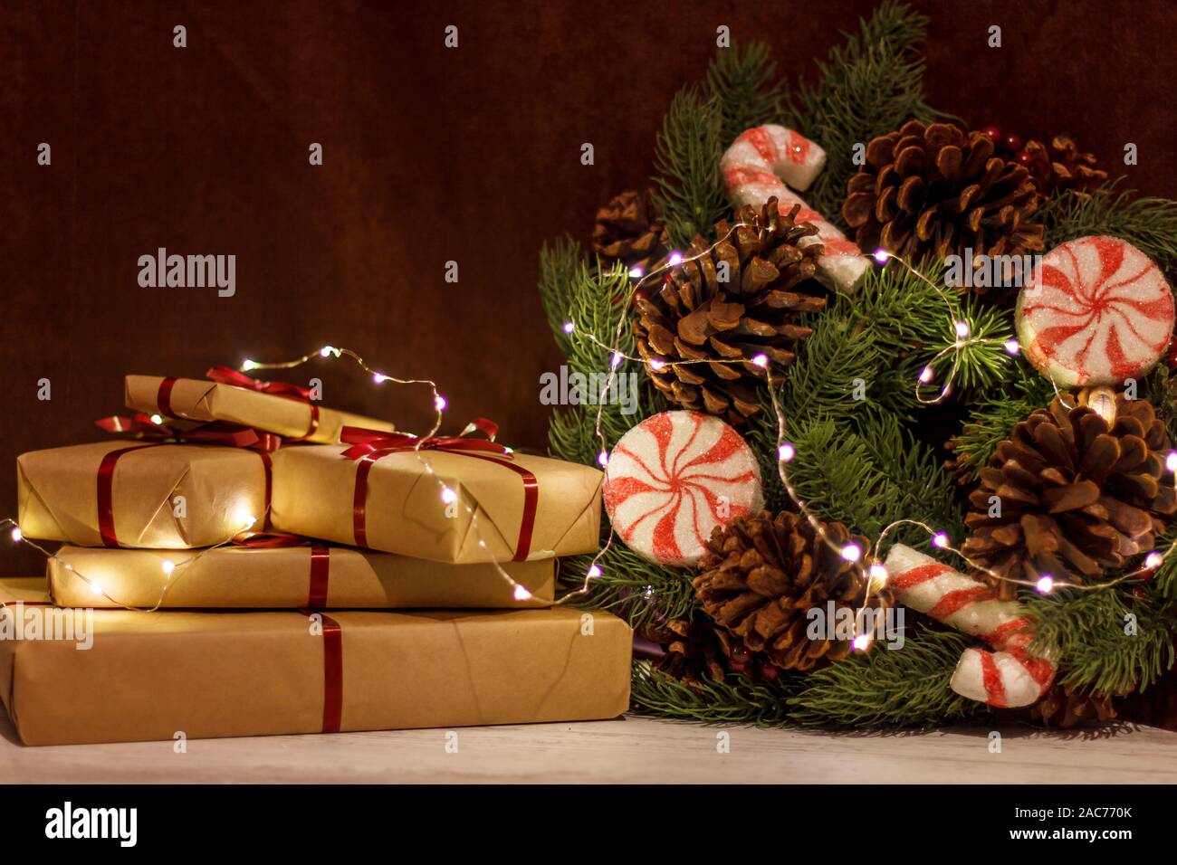Geschenkboxen und Weihnachten Kranz mit leuchtende Girlande. Stockfoto