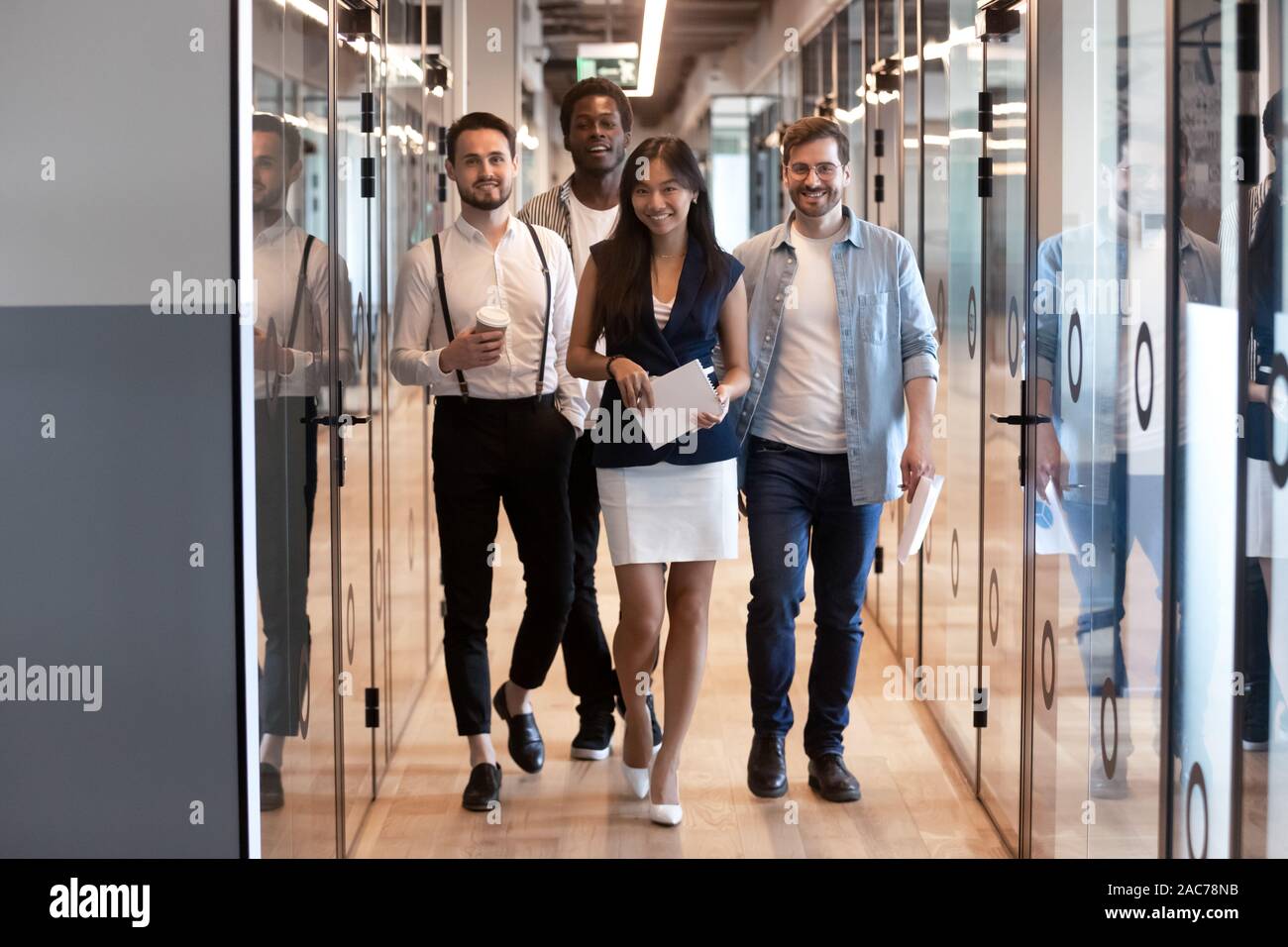 Erfolgreiche multiethnischen Mitarbeiter der Firma Spaziergang in modernen Büro Flur Stockfoto